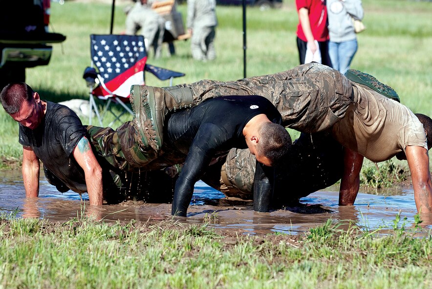 Security forces members participate in the team push-up exercise of “Team Pain” during 17th annual Crow Creek Challenge on June 18. The challenge offered 20 different events testing physical strength and mental prowess. (Photo by Jeff Allred)