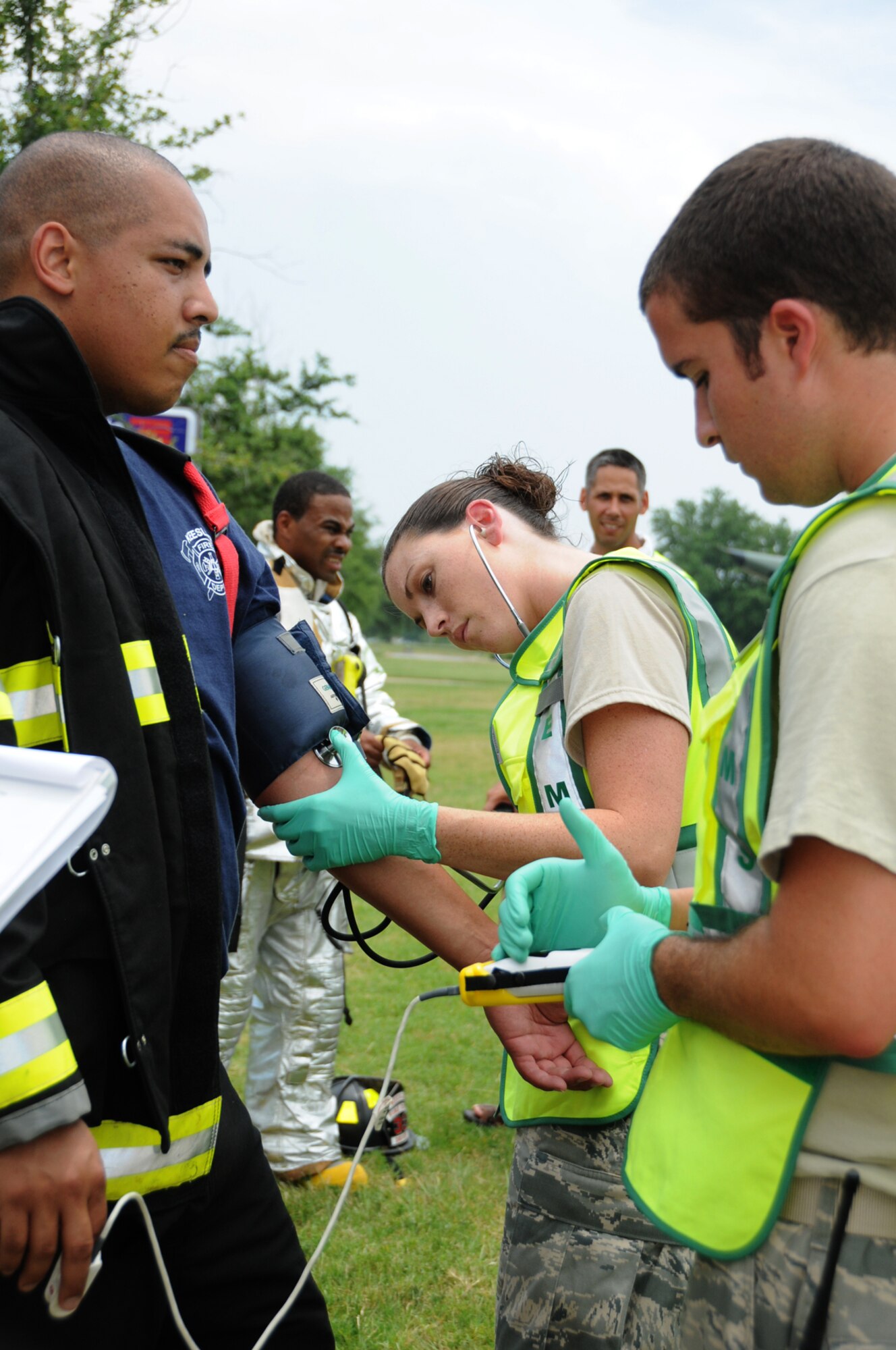 Firefighters Daniel Fish and Chad Martin are on hand as Airman Basic Brian Burton, 336th TRS, goes through the decontamination process in a parking lot across the street from the fitness center.  (U.S. Air Force photo by Kemberly Groue)
