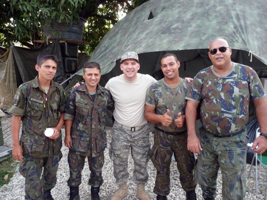 Master Sgt. Craig DeLorme, a pest management supervisor at the 128th Air Refueling Wing's Civil Engineer Squadron, Milwaukee, WI, shown center, gathers with Brazilian soldiers in a makeshift camp in Haiti.  DeLorme deployed to Port-au-Prince, Haiti, on Feb. 23, 2010, to assist in the international relief effort following a devastating earthquake on Jan. 12, 2010.  (photo submitted by Master Sgt. Craig DeLorme)