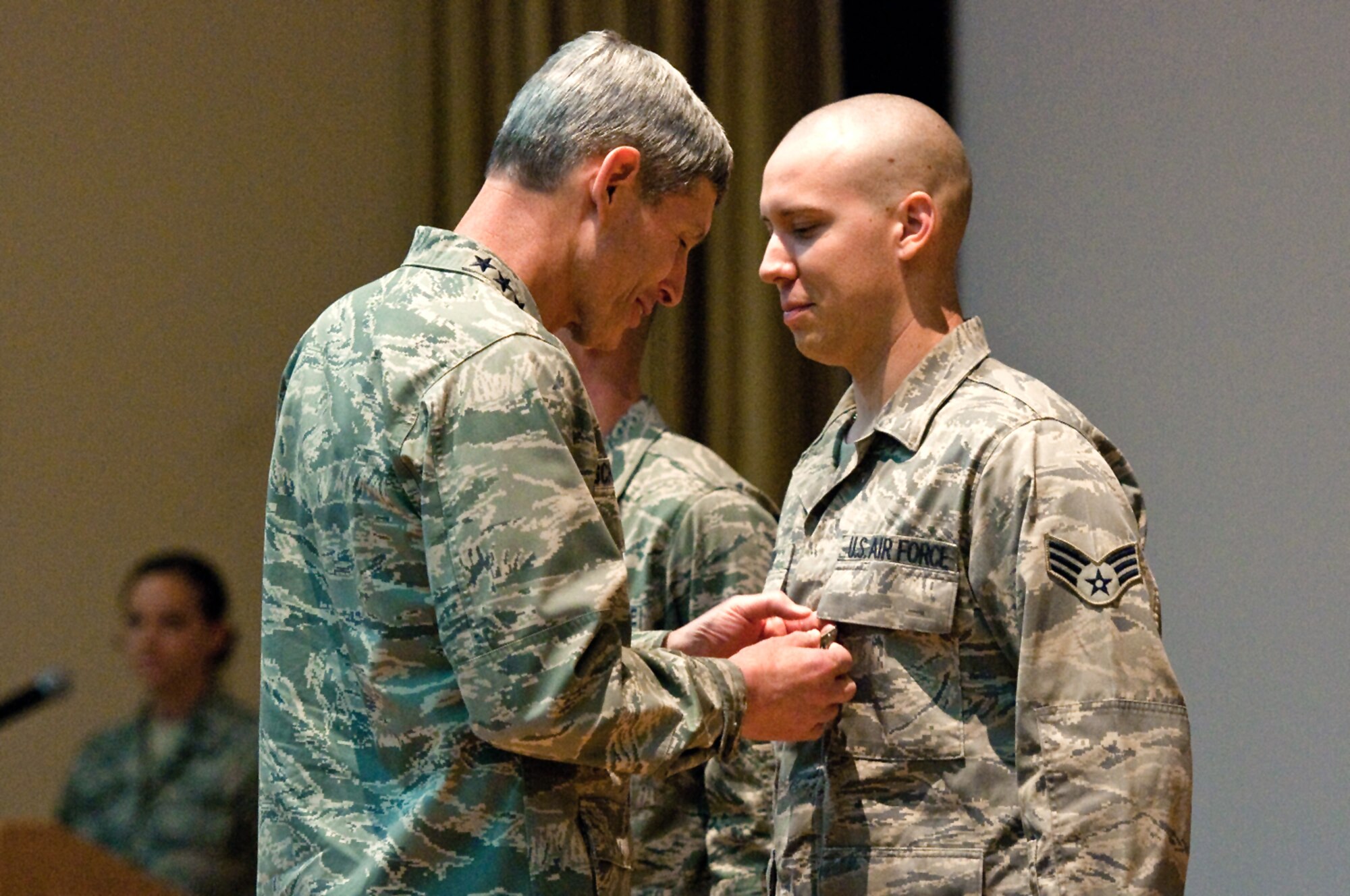 Air Force Chief of Staff Gen. Norton Schwartz presents an Air Force Combat Action Medal to Senior Airman Trent Cichy during a commander's call June 22, 2010, at the 386th Air Expeditionary Wing in Southwest Asia. Airman Cichy, a vehicle operator assigned to the 386th Expeditionary Logistics Readiness Squadron here, was injured May 27, 2010, when his supply convoy was hit by an improvised explosive device. (U.S. Air Force photo/Maj. Dale Greer)