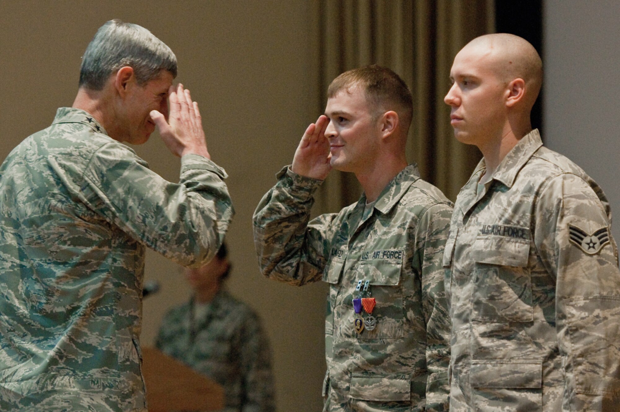 Air Force Chief of Staff Gen. Norton Schwartz presents a Purple Heart and an Air Force Combat Action Medal to Senior Airman Brian Willard during a commander's call June 22, 2010, at the 386th Air Expeditionary Wing in Southwest Asia. Airman Willard, a vehicle operator assigned to the 386th Expeditionary Logistics Readiness Squadron here, was injured May 27, 2010, when his supply convoy was hit by an improvised explosive device. (U.S. Air Force photo/Maj. Dale Greer)