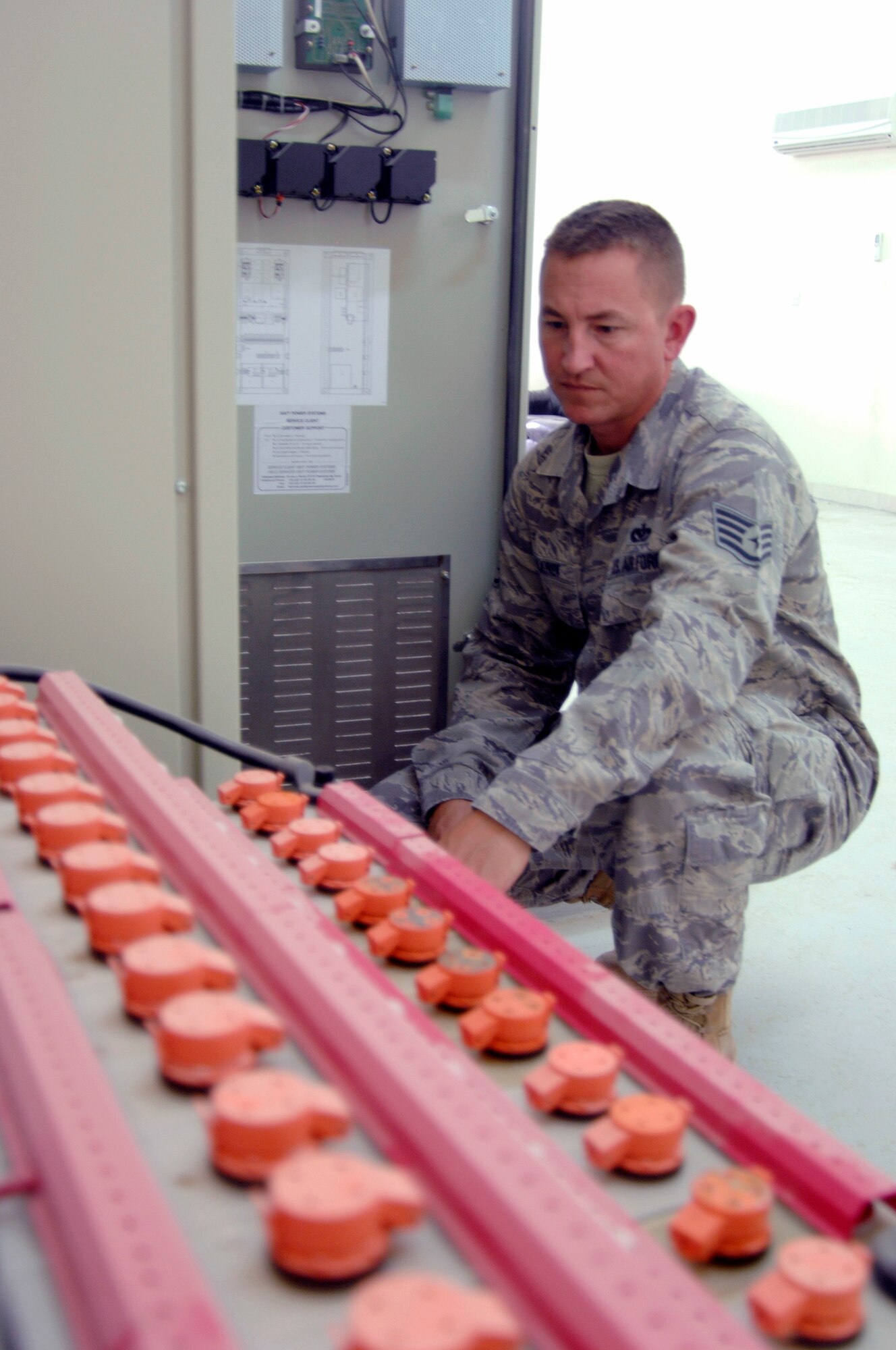 Staff Sgt. Eric Pulkinen,a electrical systems craftsman with the 380th Expeditionary Civil Engineer Squadron's Fire Department at a non-disclosed base in Southwest Asia, checks the battery bank at the high-voltage switching center. Electrical systems workers came to the forefront June 22 when the 380th AEW lost power. Their hard work after duty hours ensured power was restored as quickly as possible. Sergeant Pulkinenis is deployed from the 52nd Civil Engineer Squadron at Spangdahlem Air Base, Germany., and his hometown is Anchorage, Alaska. (U.S. Air Force Photo/Staff Sgt. Jeremy Larlee/released)