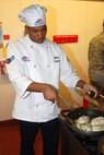 Airman 1st Class Maurice Stamps, 12th Missile Squadron chef, prepares to flip over an "Orange Chicken Delight"chicken breast at the Warrior Chef competition June 17. (U.S. Air Force photo/Airman 1st Class Kristina Overton)