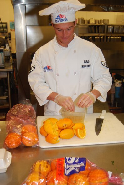 Senior Airman David Merchant, 12th Missile Squadron chef, squeezes a couple of oranges to make orange glaze for his team's signature dish at the Warrior Chef competition June 17. The common ingredient for this compeition was fresh oranges. (U.S. Air Force photo/Airman 1st Class Kristina Overton)