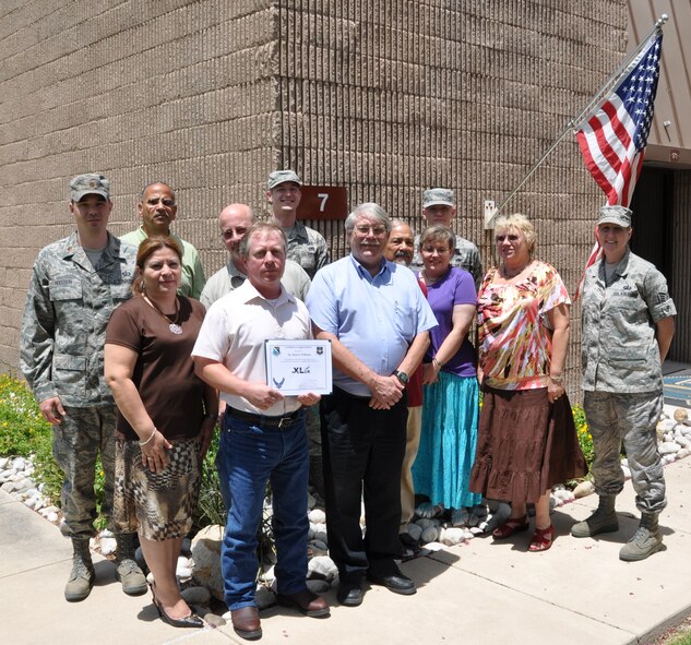 LAUGHLIN AIR FORCE BASE, Texas – Robert Williams, 47th Contracting Squadron , poses with fellow members of his squadron after being presented the XLer of the Week award by Col. David Ellis, 47th Flying Training Wing vice commander, June 23. The XLer is a weekly award chosen by 47th FTW leadership and given to individuals who consistently make outstanding contributions to Laughlin and their unit. (U.S. Air Force photo by Airman 1st Class Blake Mize)