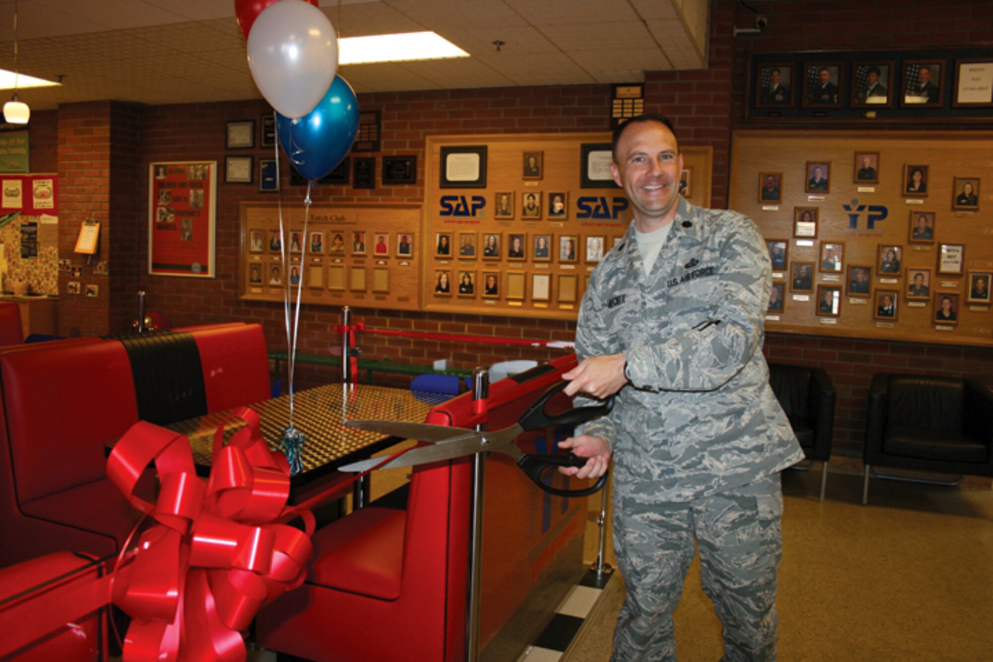Lt. Col. Kevin Heckle, 48th Force Support Squadron commander, cuts the ribbon re-opening the American Diner snack bar at the 48th FSS Youth Center on June 16. The two-month renovation project was completed in time for the end of the school year. (U.S. Air Force photo/Laura Jones)