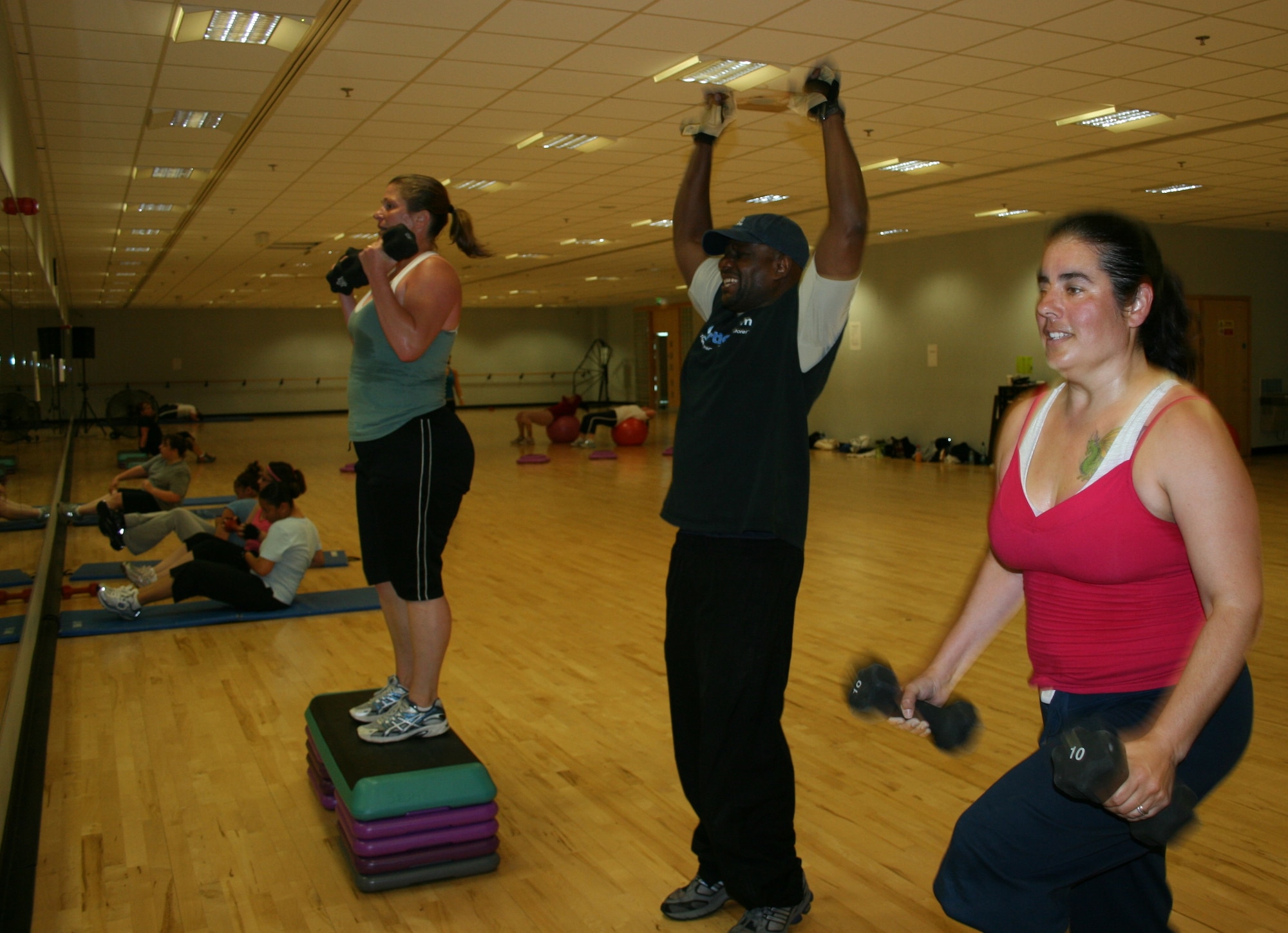 Instructor Herman Hicks (center) leads exercises during the fitness boot camp June 11 at the RAF Lakenheath Fitness Center. The camp consisted of one-hour workouts five days a week consisting of weight training, power stretching and yoga. (U.S. Air Force photo/Sara Harr)