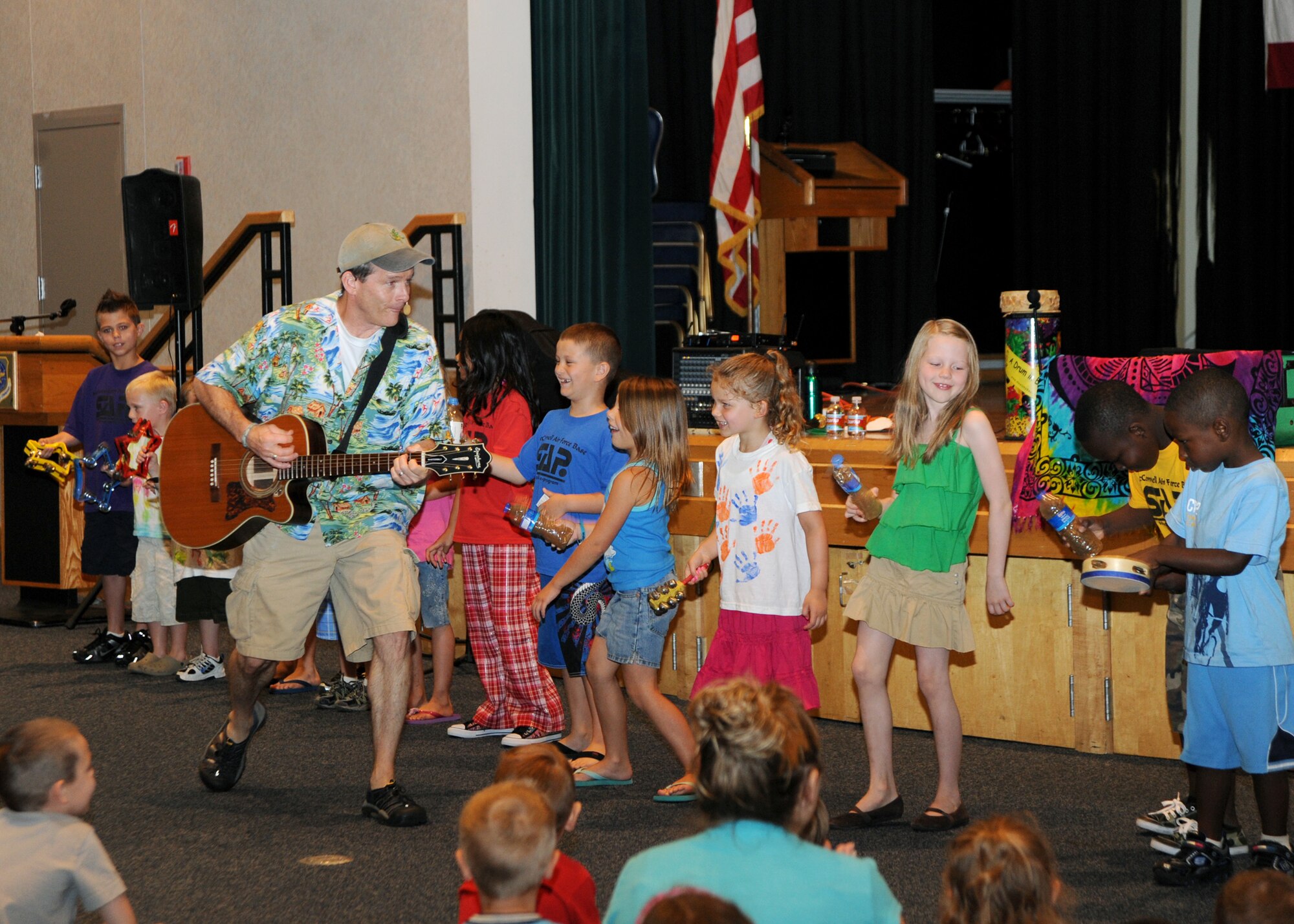 Jim Cosgrove, a musician known as “Mr. Stinky Feet,” sings and plays guitar with children from McConnell Library’s summer reading program at the Robert J. Dole Community Center,  June 18, 2010, McConnell Air Force Base, Kan.  Mr. Cosgrove sings for kids of all ages about the importance of family, friendship and fun.  This was part of the library’s summer’s theme, “Splash Down,” which encourages children to read and cool-off during the summer months. (U.S. Air Force photo/Airman 1st Class Andrea Salazar)