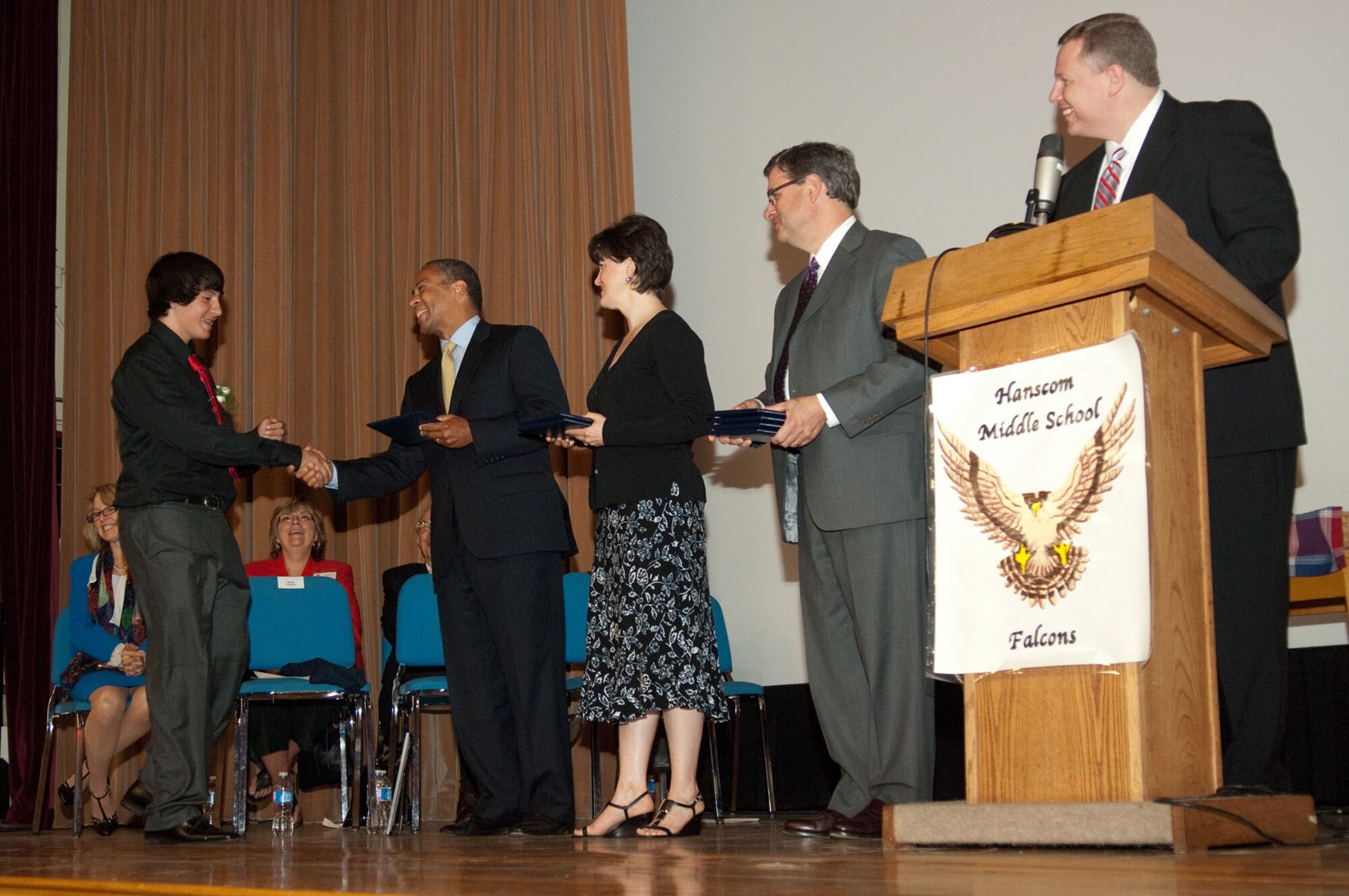 HANSCOM AIR FORCE BASE, Mass. – Joe Lewis, a Hanscom Middle School graduate, shakes Massachusetts Gov. Deval Patrick hand as he prepares to accept his diploma on June 17. Ms. Jennifer Glass, Lincoln school committee chair, Mr. Michael Brandmeyer, superintendent, and Erich Ledebuhr Hanscom Middle School principal, wait to greet the recent graduate, as well. Governor Patrick visited the base to take part in Hanscom Middle School’s graduation ceremony. (U.S. Air Force photo by Rick Berry)