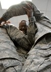 Staff Sgt. Cedric Dottin, 919th Aircraft Maintenance Squadron, holds onto his teammates as they all try to squeeze into a tiny box on the floor during the second week of the NCO development course at Duke Field.  22 919th Special Operations Wing NCOs and soon to be NCOs attended the two-week course to learn about leadership, management and communication.  U.S. Air Force photo /Tech. Sgt. Samuel King Jr.