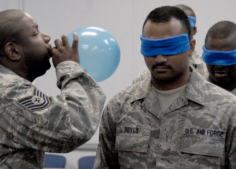 An instructor blows up a balloon in an attempt to distract students during the “land mine crossing” portion of the second week of the NCO development course at Duke Field.  22 919th Special Operations Wing NCOs and soon to be NCOs attended the two-week course to learn about leadership, management and communication.  U.S. Air Force photo /Tech. Sgt. Samuel King Jr.