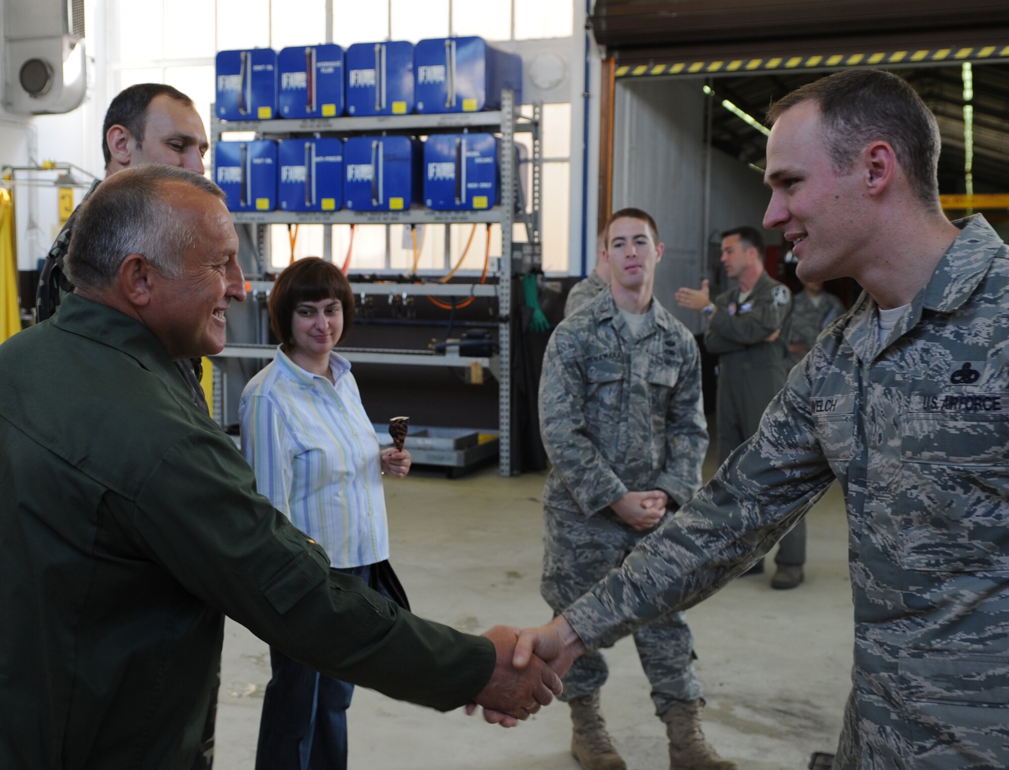 U.S. Air Force Master Sgt. Thomas Welch, 86th Maintenance Squadron aerospace ground equipment (AGE) assistant flight chief, shakes hands with Ukrainian Air Force member after a tour of the AGE facility during a visit to Ramstein Air Base, Germany, June 24, 2010.  The goal of the Ukrainian visit was to help advance military interoperability and build international partnerships. (U.S. Air Force photo by Senior Airman Caleb Pierce)