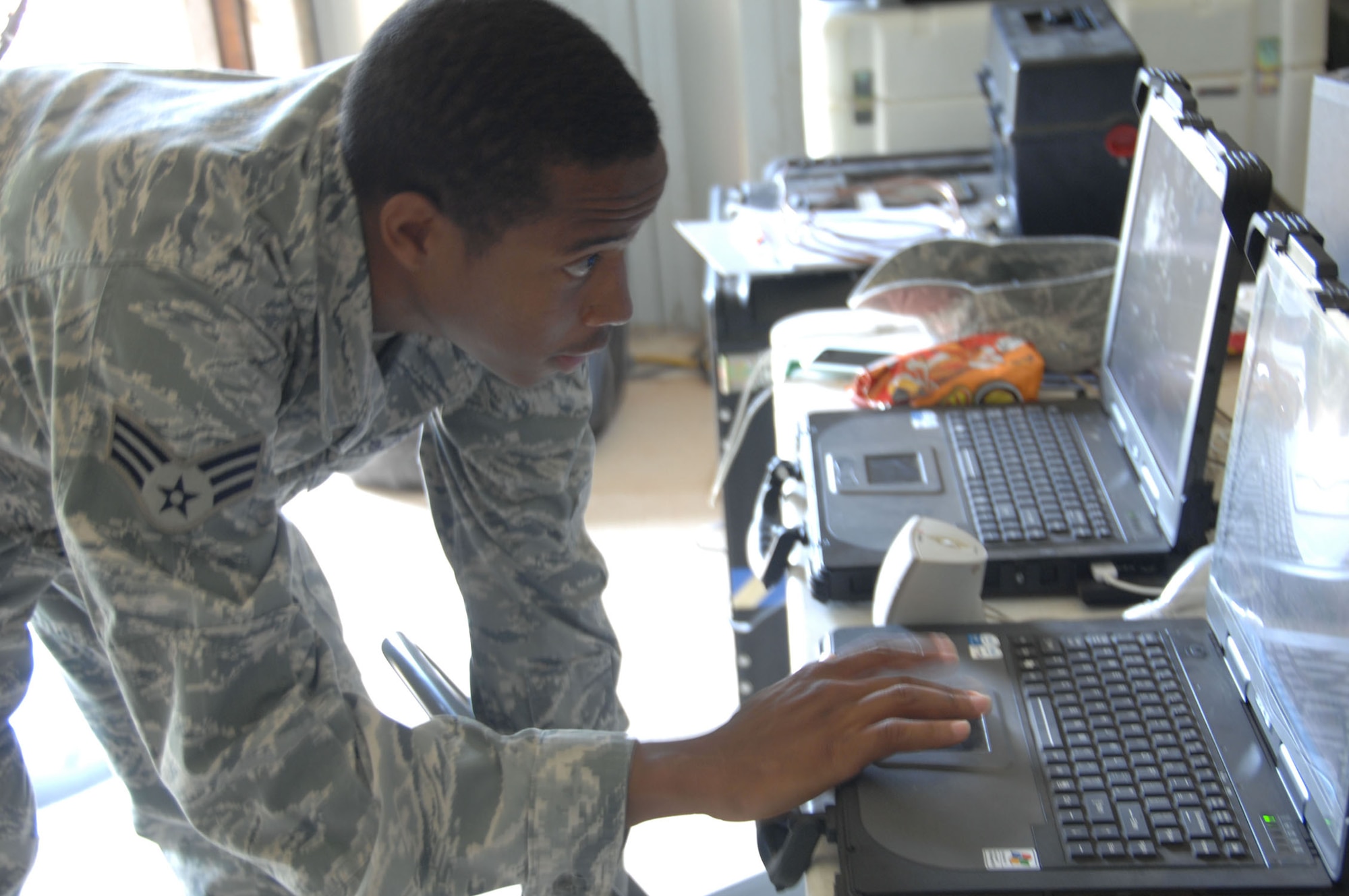 ANDERSEN AIR FORCE BASE, Guam - Senior Airman Marcus Prentiss, 644th Combat Communications Squadron cyber transport systems and voice systems technician, uses a laptop computer to upgrade software on a secure telephone console here June 23. Airman Prentiss was selected by Master Sgt. Shawn Bendixson, 644th CBCS first sergeant, for his can-do attitude and professionalism. (U.S. Air Force photo by Senior Airman Shane Dunaway)  