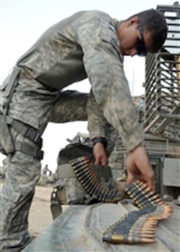 U.S. Army Pfc. Jeffrey Brunk, Bravo Company, 5th Battalion, 20th Infantry Regiment, 2nd Infantry Division, loads ammunition for an M-240B machine gun into a pouch prior to conducting a squad live-fire exercise at the Kirkush Military Training Base in Diyala province, Iraq, on June 10, 2010.  