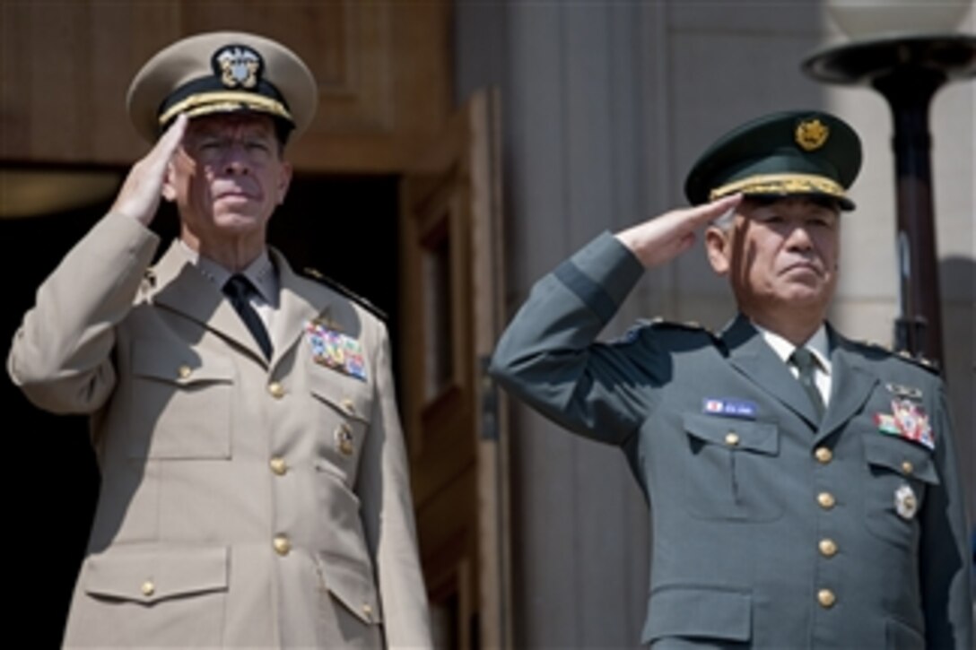Chairman of the Joint Chiefs of Staff Adm. Mike Mullen and Chief of Staff of the Japanese Self Defense Force Gen. Ryoichi Oriki render honors during the playing of their countries' respective national anthems at the Pentagon on June 24, 2010.  