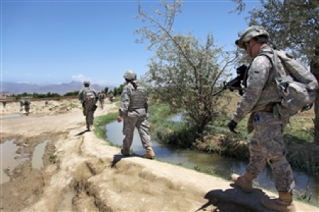 U.S. Army soldiers patrol along a canal to the village of Sabikhel, Parwan province, Afghanistan, June 21, 2010.
