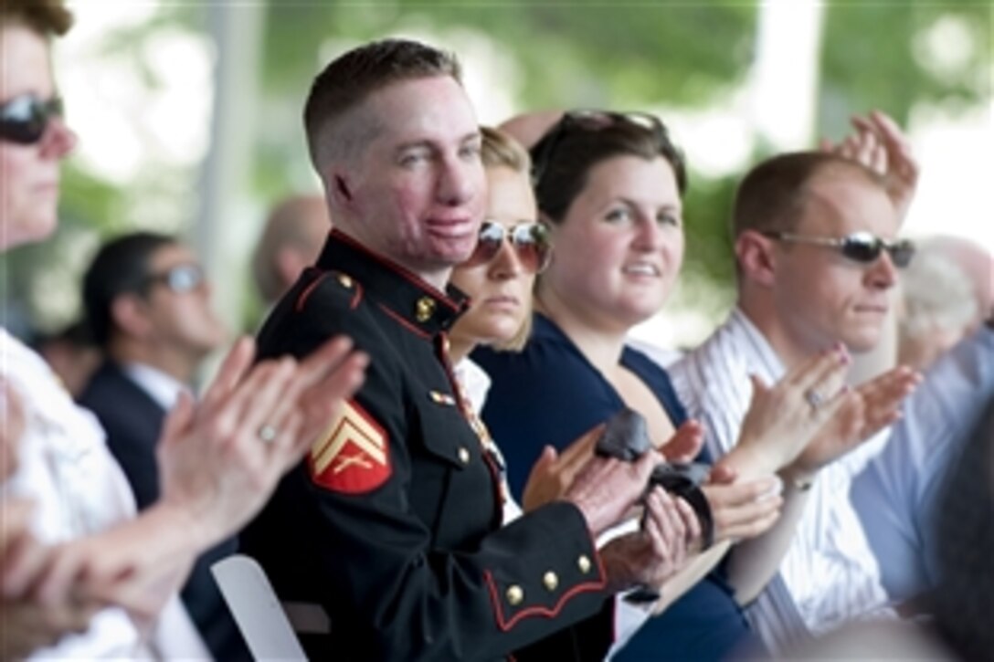 U.S. Marine Corps Cpl. Aaron Mankin, a wounded warrior, applauds during a dedication ceremony for the National Intrepid Center of Excellence at Bethesda National Naval Medical Center, Md., June 24, 2010. 