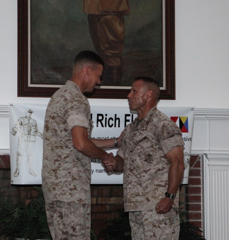 (from left to right) Col. Richard P. Flatau Jr., outgoing commanding officer of Marine Corps Base Camp Lejeune, shakes hands with incoming commanding officer, Col. Daniel J. Lecce, during a change-of-command ceremony at Paradise Point Officers’ Club aboard the base, June 25.  The handshake signified the end of Flatau’s two-and-a-half year reign and the beginning of Lecce’s new role as commanding officer.