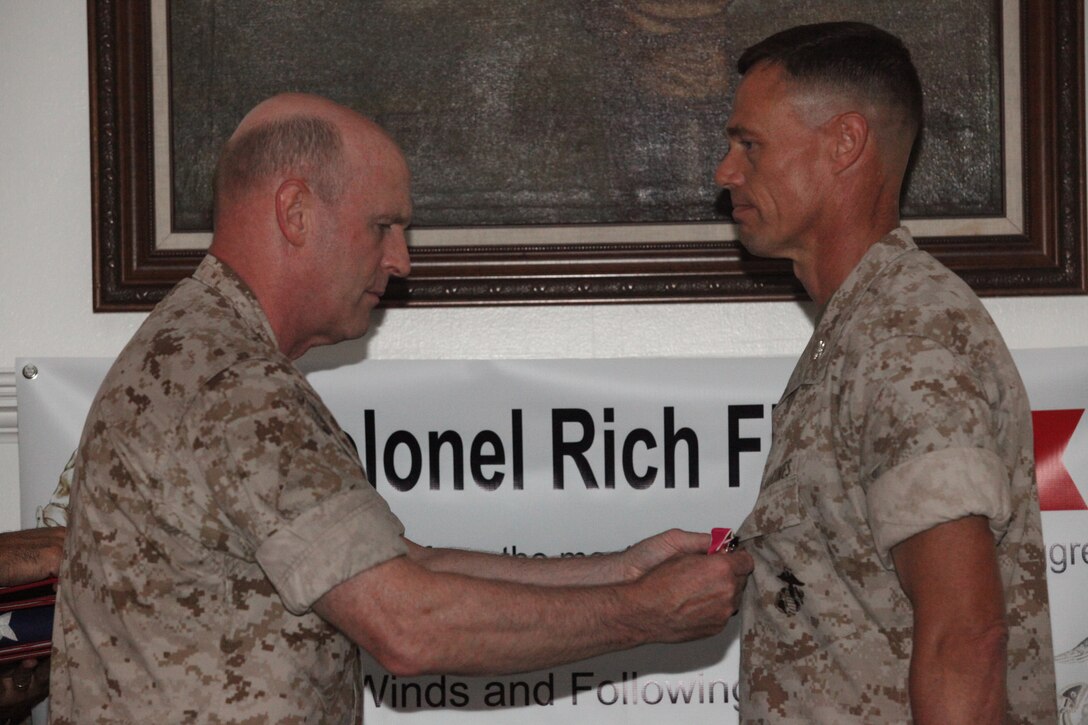 Maj. Gen. Carl B. Jensen (left), commanding general of Marine Corps Installations East, pins the Legion of Merit medal on Col. Richard P. Flatau Jr., outgoing commanding officer of Marine Corps Base Camp Lejeune, during a change-of-command ceremony at Paradise Point Officers’ Club aboard the base, June 25.  Flatau is retiring from the Marine Corps after 27 years of active-duty service and relinquished command of the base to Col. Daniel J. Lecce.