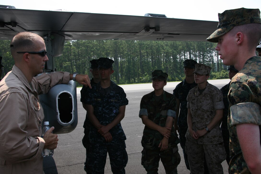 Midshipmen look at an AV-8B Harrier, a KC-130J Hercules and an EA-6B Prowler parked on the “foxtrot” taxiway at MCAS Cherry Point, June 25. The midshipmen are from across the country and visited the air station as part of their career orientation and training for midshipmen, or CORTRAMID.::r::::n::::r::::n::