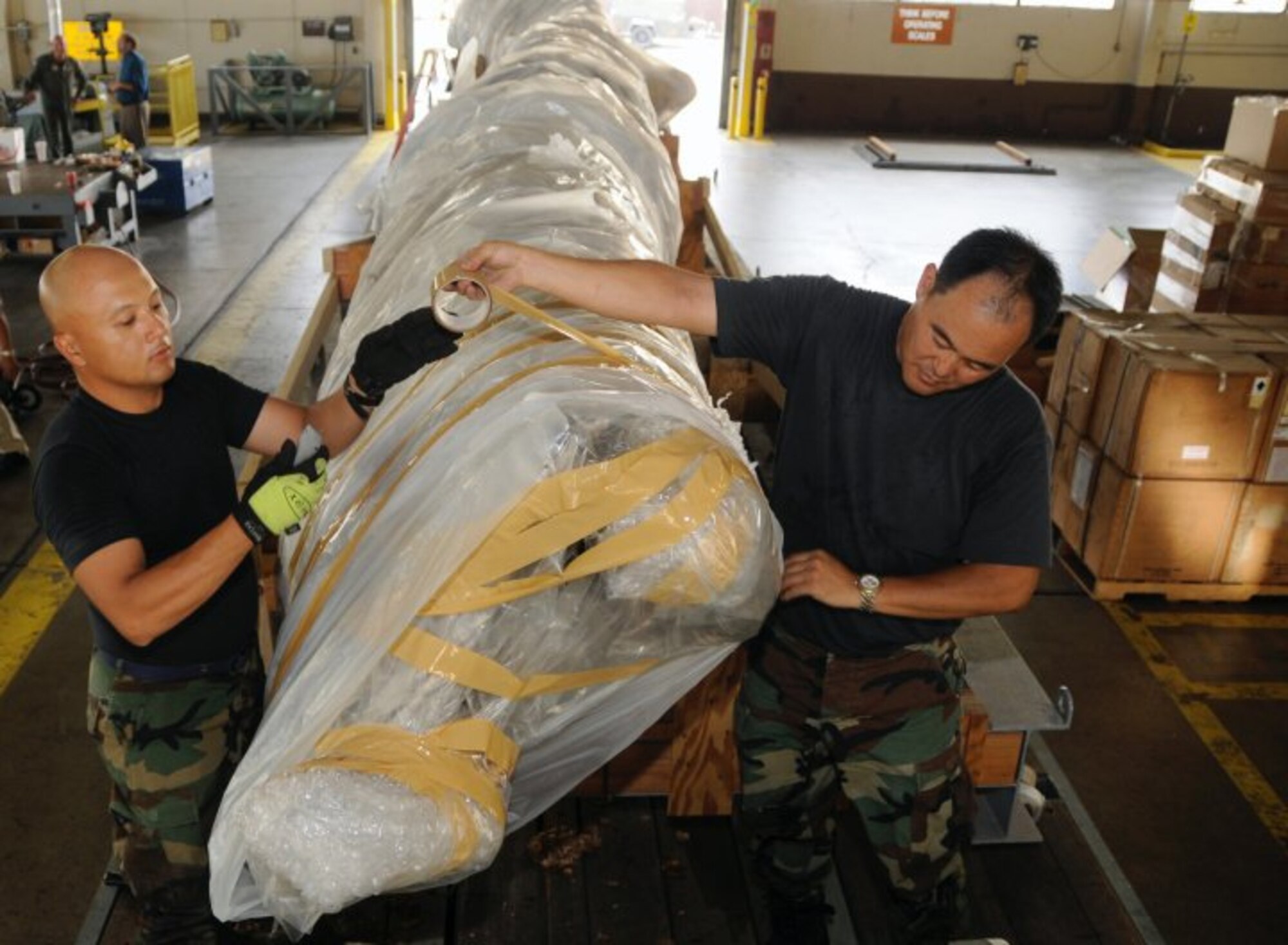 Airman 1st Class Rodolfo Fabro and Master Sgt. Daryl Oshiro, both assigned to 154th Wing Hawaii Air National Guard, strap in the 40-foot mast that was originally attached to USS Oklahoma (BB 37). The battleship Oklahoma, named after the 46th state, was sunk during the Dec. 7, 1941 attack. The mast itself was dredged up more than 60 years later to be transported to the Muskogee War Memorial in Oklahoma. (U.S. Navy photo by Mass Communication Specialist 2nd Class (SW) Mark Logico)