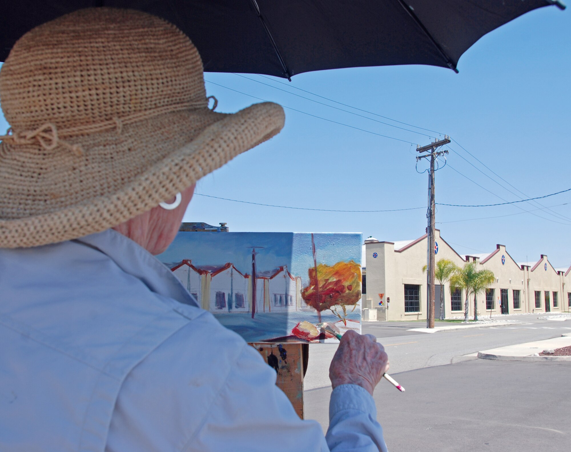 Riverside resident Helen L. Bell works on an oil painting of March’s historic hangars. Mrs. Bell, the wife of retired Air Force Col. Paul Bell, has captured many of March Field’s historic facilities on canvas, including the wing headquarters building. The original painting hangs in the Hap Arnold House. (U.S. Air Force photo by Megan Just)