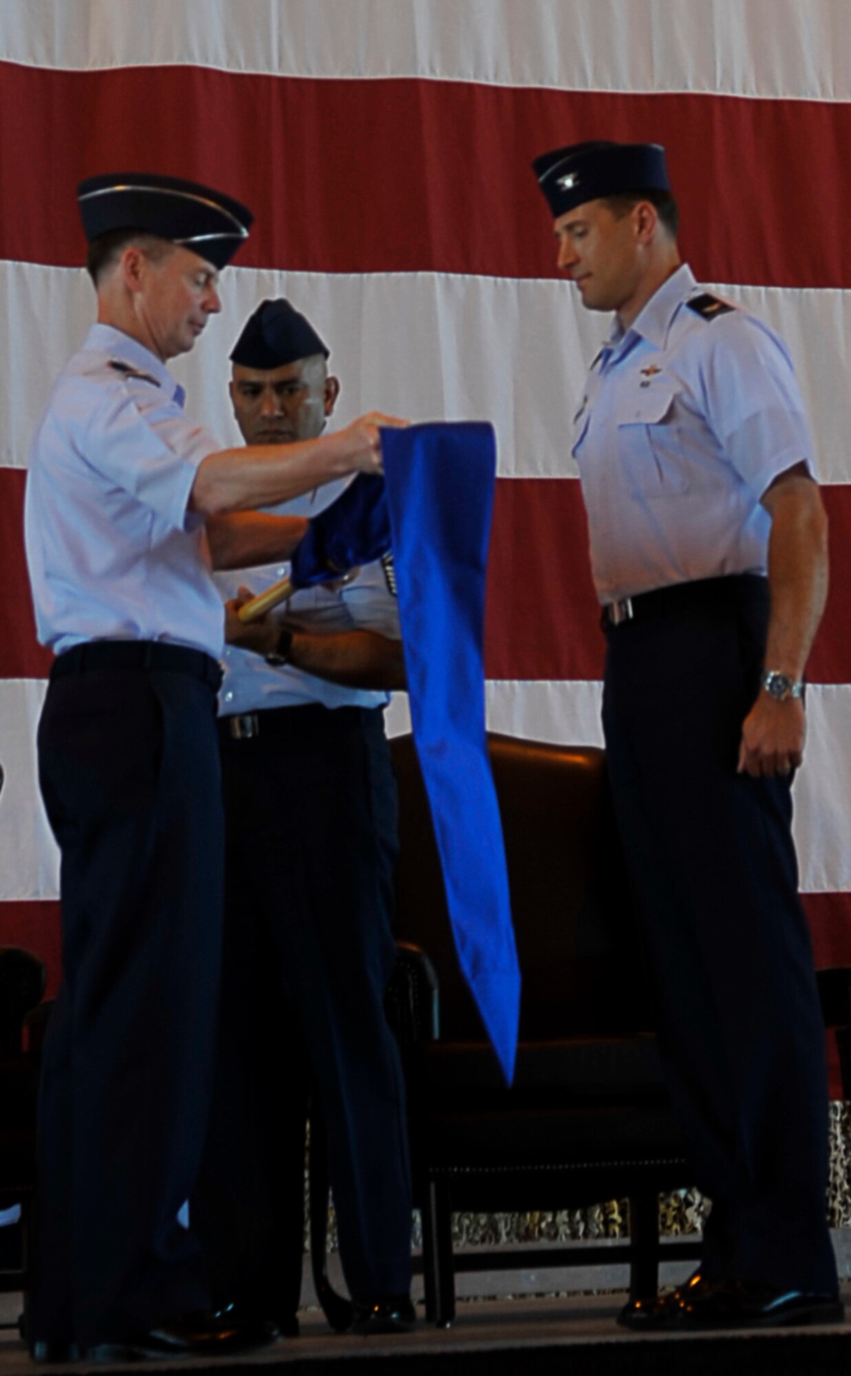 HOLLOMAN AIR FORCE BASE, N.M. --Lt. Gen. Glenn Spears, 12th Air Force commander, and Chief Master Sgt. Gerardo Tapia, 49th Wing command chief, uncase the 49th Wing guidon during the 49th WG Change of Command at hangar 301, June 25, 2010. The 49th WG guidon was then presented to Col. David Krumm, the first 49th WG commander. (U.S. Air Force photo by Airman 1st Class Joshua Turner / Released)