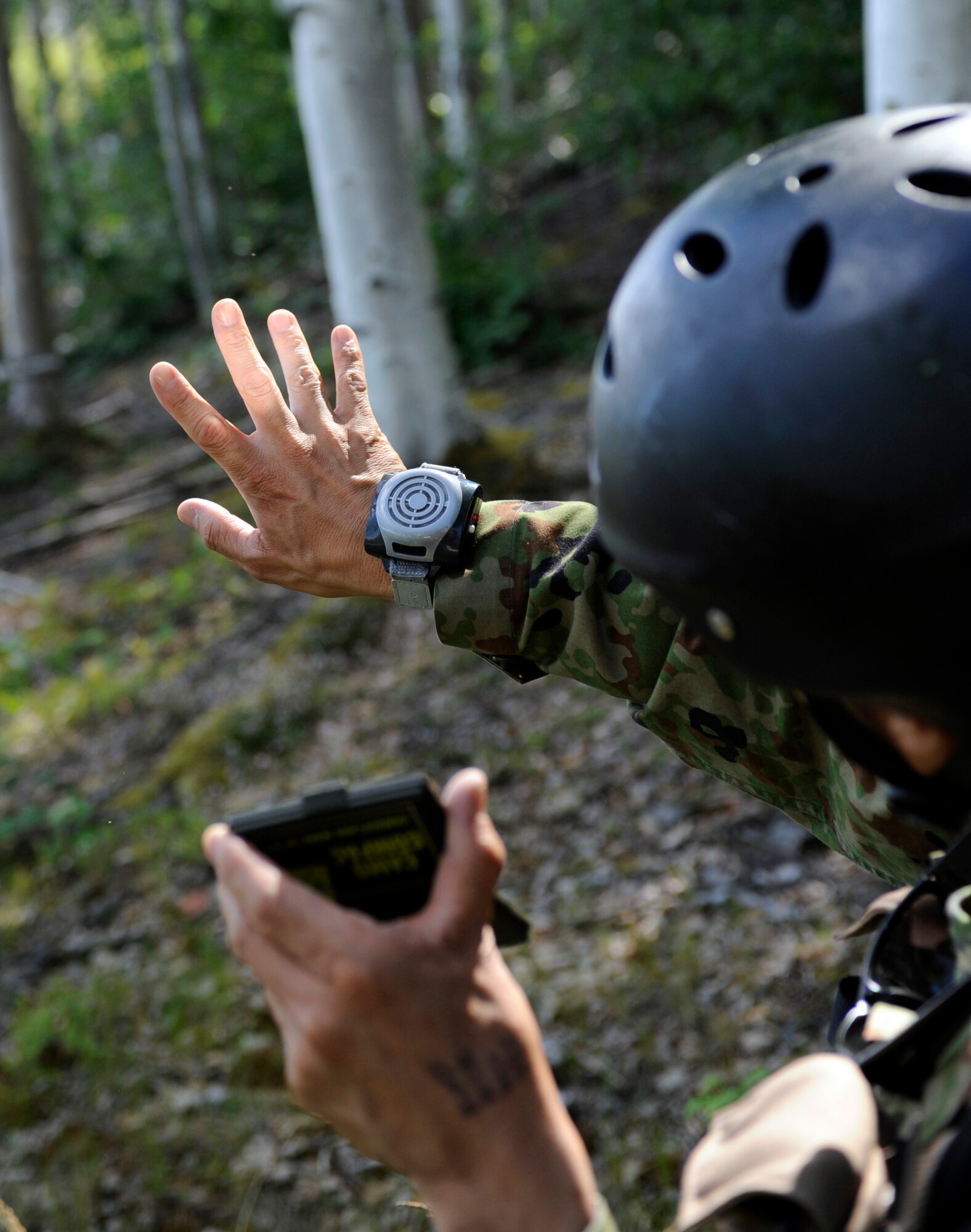 A Japanese Air Self Defense Force Pararescueman uses a signal mirror June 23, 2010, Eielson Air Force Base, Alaska. The JASDF Pararescueman was signaling Army OH-58 Kiowa helicopters to alert a ground rescue force to his position. Signal mirrors can be seen up to 40 miles in perfect conditions. (U.S. Air Force photo/airman 1st Class Willard E. Grande II)