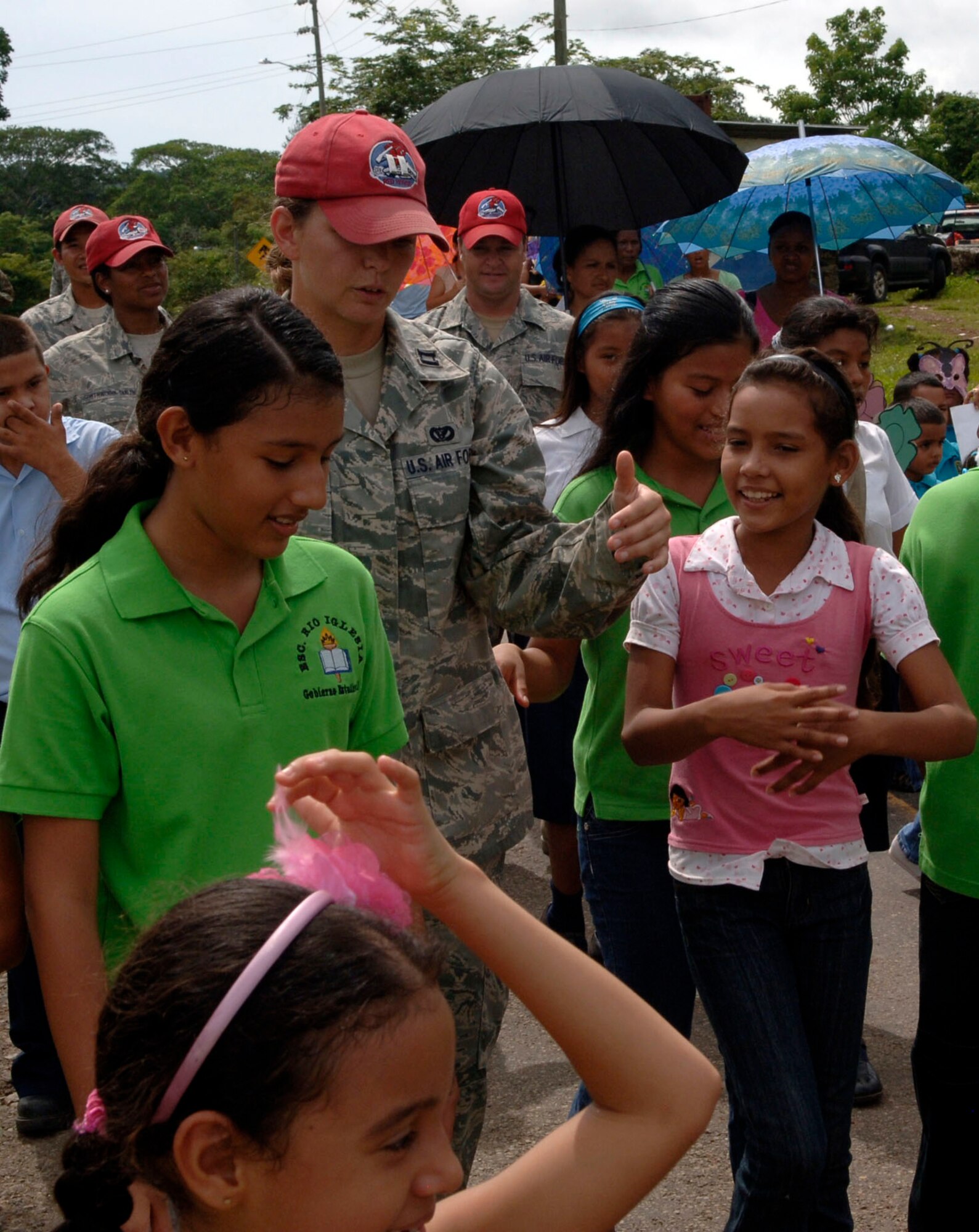 Capt.Brandy Caffee, 820th Expeditionary RED HORSE Squadron, speaks with children while marching in a parade of students, parents and U.S. service members in front of the Rio Iglesia elementary school June 24. Personnel from New Horizons Panama 2010 took time out of the construction schedule to support the school's conservation day festival. (U.S. Air Force photo/Tech. Sgt. Eric Petosky)