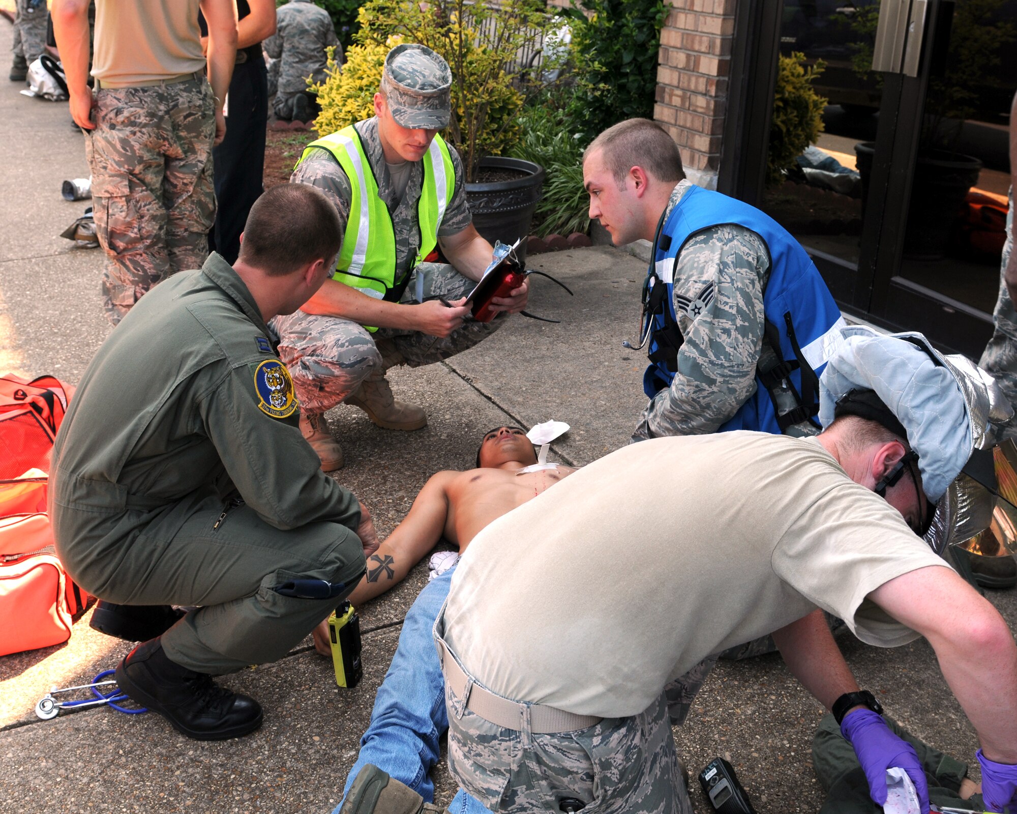 BLAZE Team responders and exercise evaluation team members discuss a portion of the exercise while helping a “victim,” June 17. (U.S. Air Force photo/Elizabeth Owens).