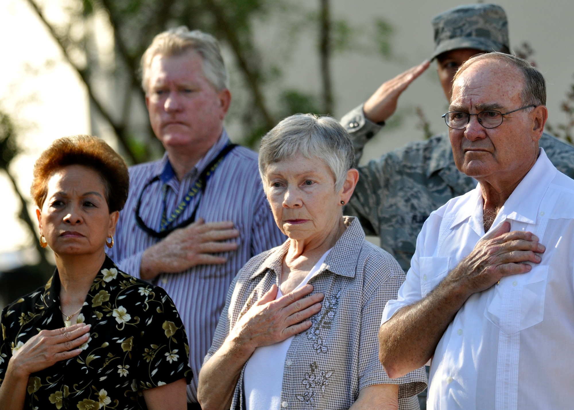 Family members of the victims of the Khobar Towers bombing listen to the National Anthem during a ceremony, which marked the 14th anniversary of the tragedy, June 25 at Eglin Air Force Base, Fla.  Almost 100 friends, family and current members of the 33rd Fighter Wing gathered for a remembrance ceremony near the memorial dedicated to the heroism of 12 Airmen lost. The 33rd FW suffered 105 wounded personnel and accounted for 12 of the 19 Airmen killed in the Khobar Towers terrorist attack June 25, 1996. (U.S. Air Force Photo/ Samuel King Jr.)