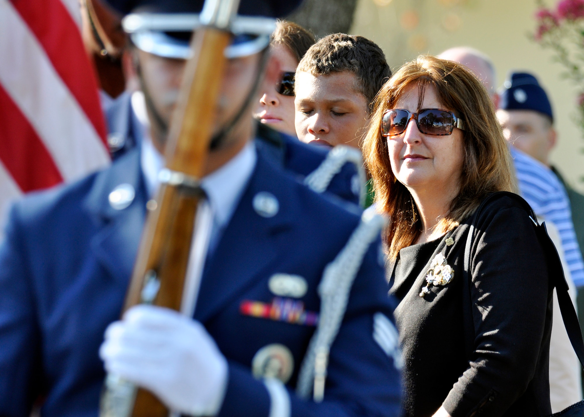 Bridget Brooks, 36th Electronic Warfare Squadron, and other family members of the victims of the Khobar Towers bombing watch as the flag is carried off by the base honor guard during memorial ceremony June 25 at Eglin Air Force Base, Fla.  Mrs. Brooks lost her son, Airman 1st Class Joseph Rimkus, in the attack. Almost 100 friends, family and current members of the 33rd Fighter Wing gathered for a remembrance ceremony near the memorial dedicated to the heroism of 12 Airmen lost. The 33rd FW suffered 105 wounded personnel and accounted for 12 of the 19 Airmen killed in the Khobar Towers terrorist attack June 25, 1996. (U.S. Air Force Photo/ Samuel King Jr.) 