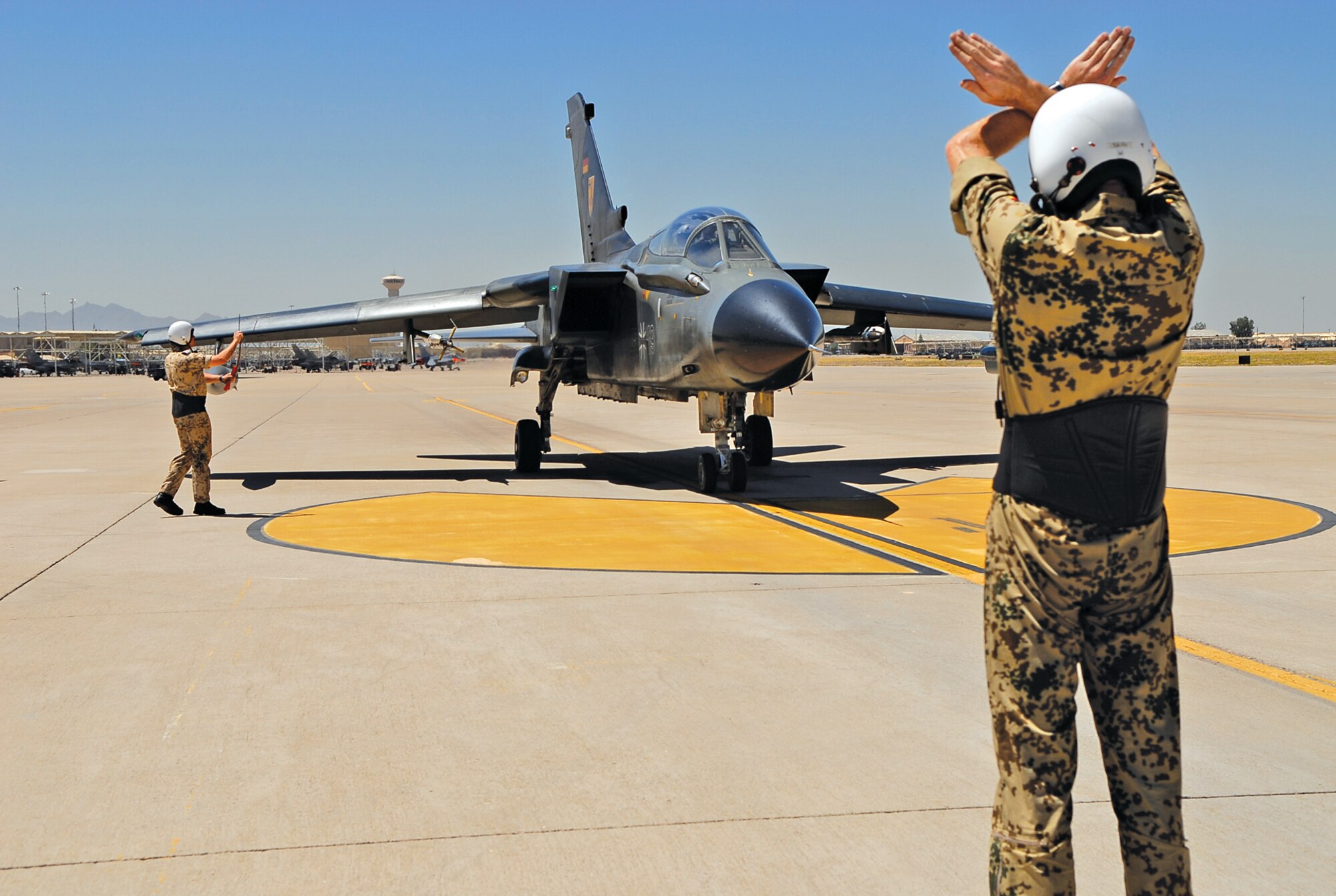 German Air Force Master Sgt. Frank Strobel, a maintainer from Holloman Air Force Base, N.M., marshalls in a Panavia Tornado PA-200 June 17 on the Luke AFB runway. The German airmen were attending a week-long fighter weapons instructor course while the 310th Fighter Squadron provided adversary support. (U.S. Air Force photo by Airman 1st Class Ronifel Yasay)