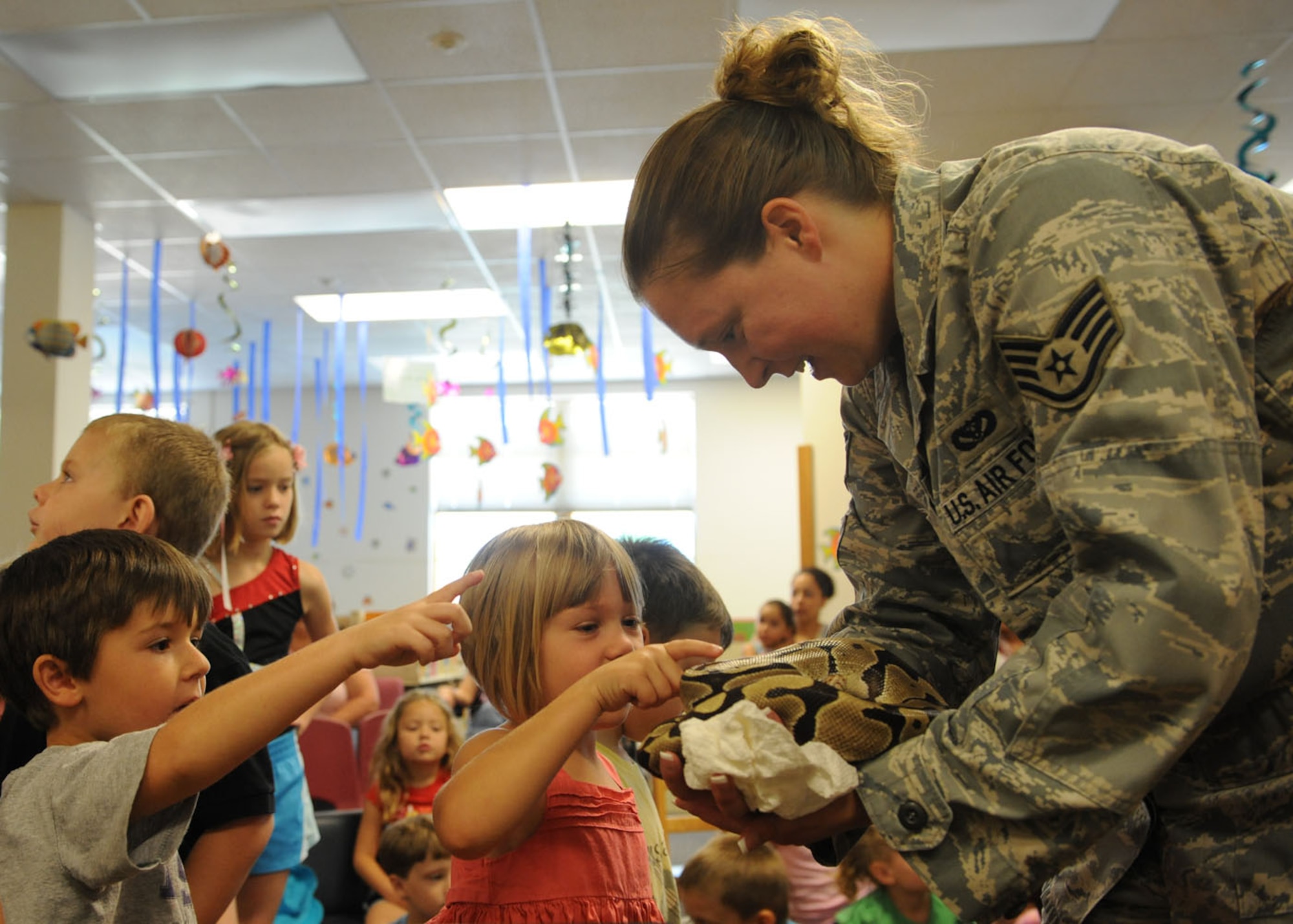 DYESS AIF FORCE BASE, Texas—Staff Sgt. Terri Williams, 7th Civil Engineer Squadron, allows children from the Child Development Center to  pet the snake she is holding here June 23 as part of a summer reading program at the library. Members from the 7th Civil Engineer Squadron brought snakes and taught the children how to identify and handle chance encounters with these animals. The summer reading program consists of informative speakers, crafts, snacks and prizes to entice children to read and learn. For more information about the base library and upcoming programs, call (325) 696-2618. (U.S. Air Force photo/ Airman 1st Class Shannon Hall)