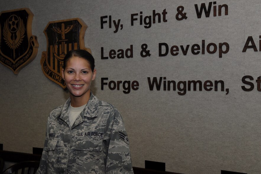 Senior Airman Aymee Fowkes, 1st Special Operations Wing Plans and Programs resource advisor, poses in front of the Air Force Special Operations Command and 1st SOW logos at the wing conference room at Hurlburt Field, Fla., June 25, 2010. Airman Fowkes was selected for this week's "Tip of the Spear" spotlight. (DoD photo by U.S. Air Force Airman 1st Class Joe McFadden) (RELEASED) 