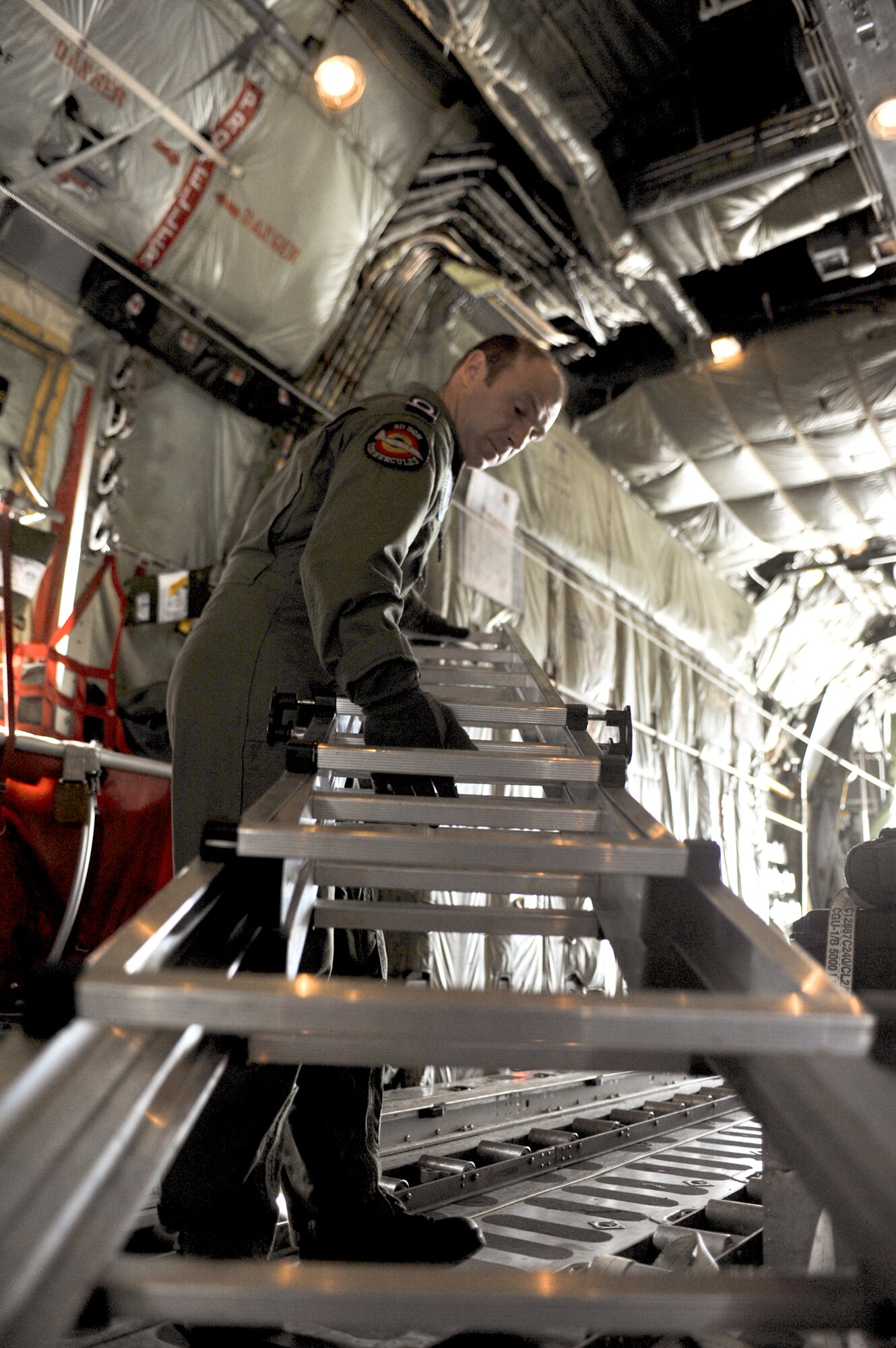 Belgian Air Component Adjudant Gert Van Den Berghe moves a ladder before a Belgian C-130 Hercules takes off June 22, 2010, at Joint Base Elmendorf-Richardson, Alaska. This was the first time the BAC has participated in Red Flag-Alaska. Adjudant Van Den Berghe is a BAC 15th Air Transport Wing 20th Squadron loadmaster. (U.S. Air Force photo/Airman 1st Class Christopher Gross)
