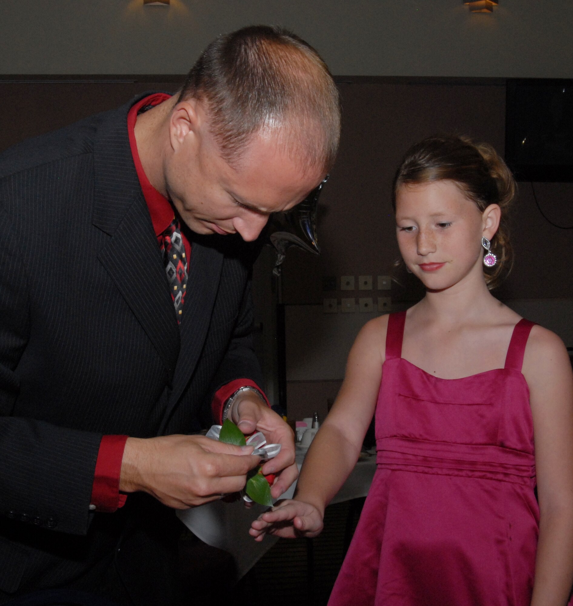 Tech. Sgt. Douglas Hackelton, 315th Training Squadron, gives his daugher, Hannah, a corsage during the Sixth Annual Daddy/Daughter Dinner Dance June 24 at the Event Center. More than 20 dads and daughters took part in this year's Hollywood-themed event. (U.S. Air Force photo/Connie Hempel)