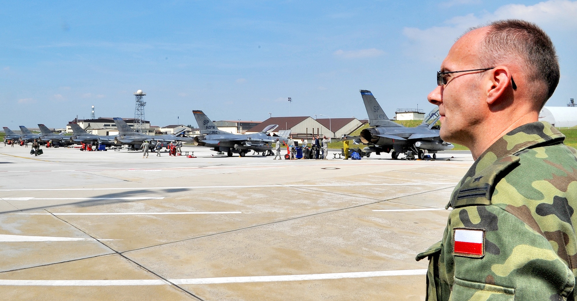 SPANGDAHLEM AIR BASE, Germany – Maj. Andriej Pokladek, Polish Air Force 32nd Air Tactical Base, Poland, observes as Airmen from the 52nd Aircraft Maintenance Squadron perform maintenance on F-16 Fighting Falcons during a U.S. Air Forces in Europe Operational Readiness Inspection here June 23. Members from headquarters USAFE and Aviano Air Base’s 31st Fighter Wing escorted their Polish counterparts during the USAFE ORI. The Polish Air Force’s 32nd Tactical Air Base, which includes F-16 Fighting Falcons, will have its first ever practice NATO tactical evaluation in August. (U.S. Air Force photo/Airman 1st Class Nick Wilson)