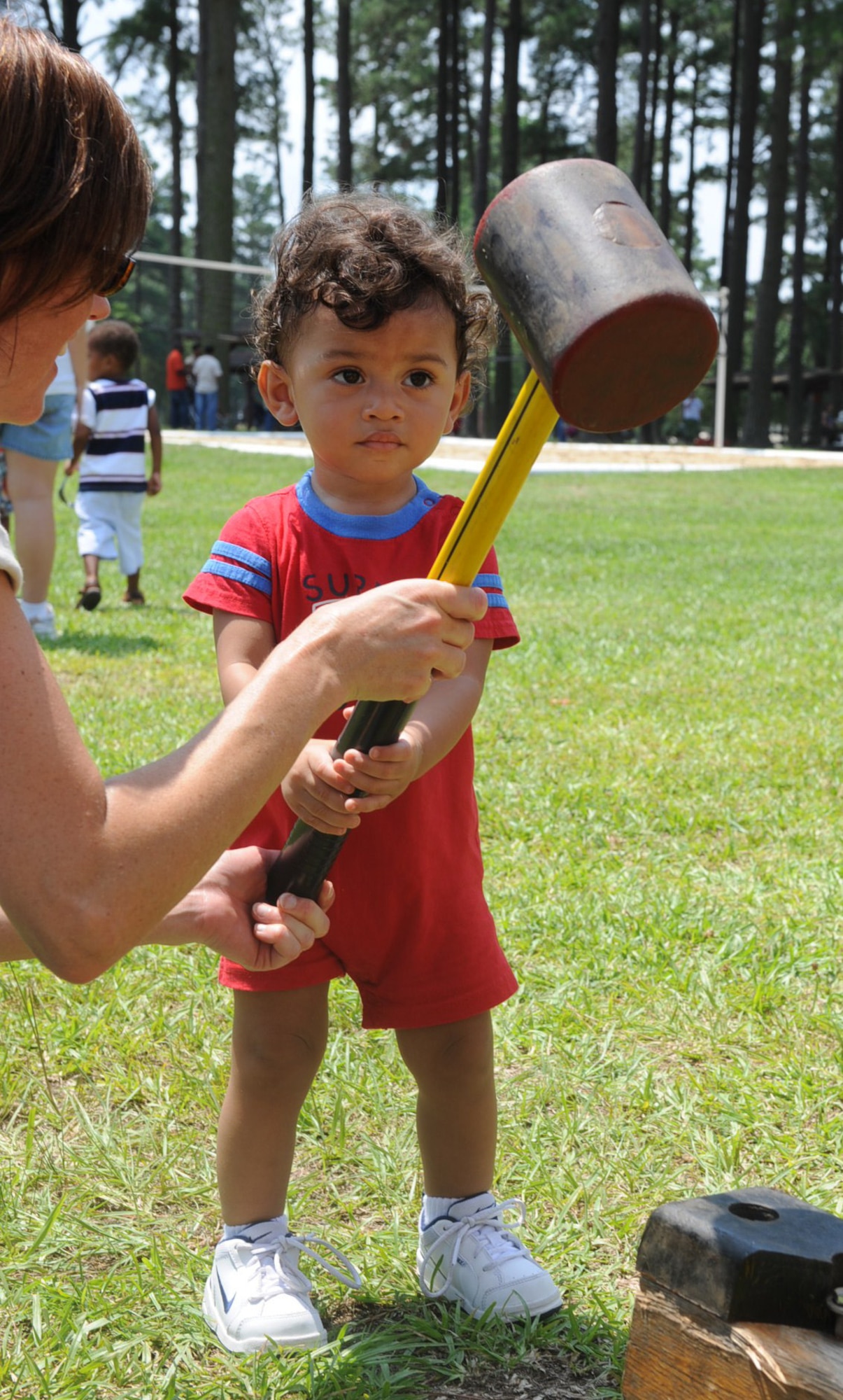 SEYMOUR JOHNSON AIR FORCE BASE, N.C. -- Lori Smith helps Mateo Briggs hold a mallet for a strength test game during Family Appreciation Day festival here June 19, 2010. Festival activities included a rock climbing wall, harness jumping and volleyball. Mrs. Smith hails from Goldsboro. Mateo is the son of Staff Sgt. Kwame Briggs, 916th Air Refueling Wing crew chief. (U.S. Air Force photo/Senior Airman Gino Reyes)