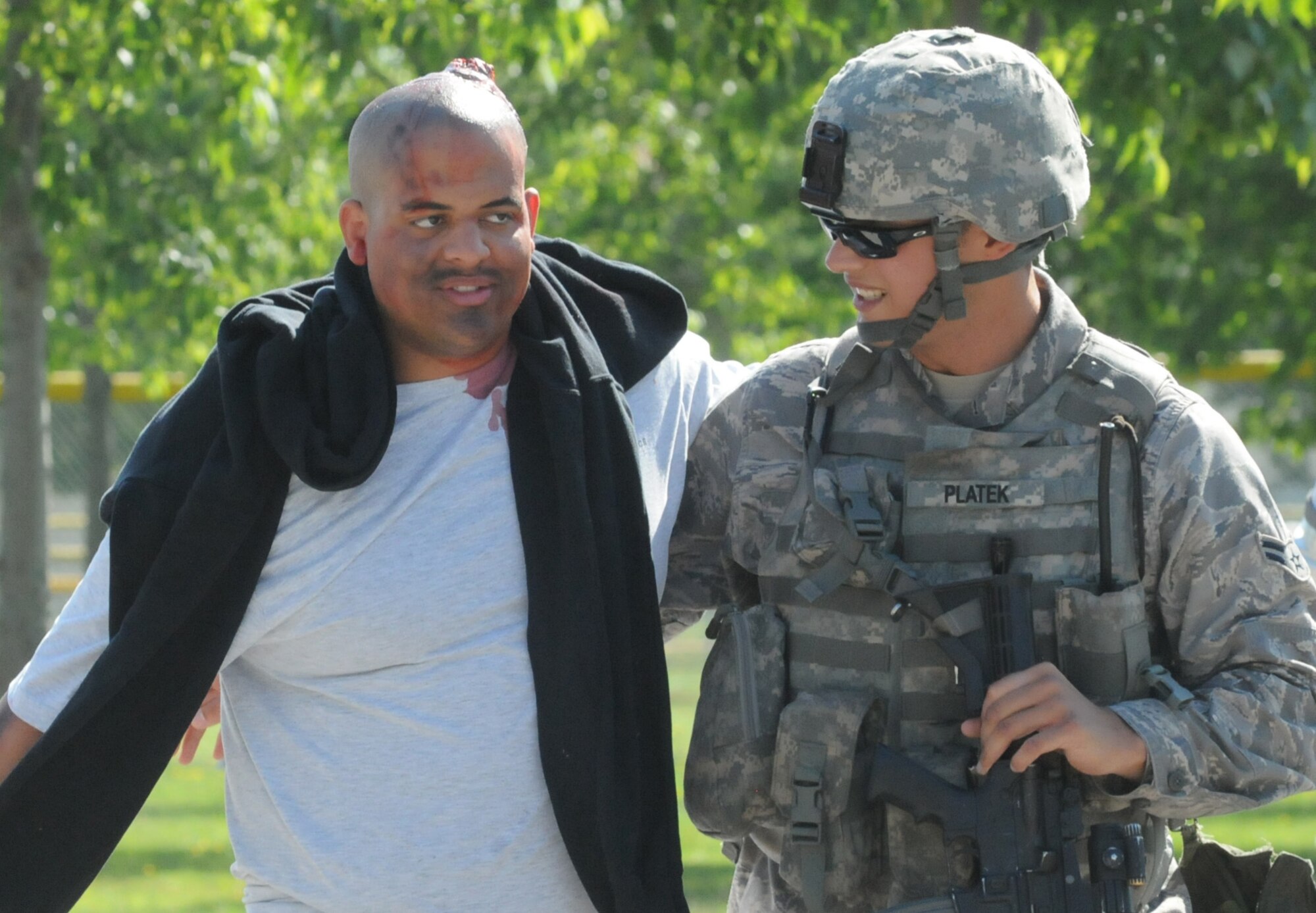 Airman 1st Class Andrew Platek (rght), 31st Security Forces Squadron security response team leader, escorts a "wounded" victim to safety as part of a major accident response exercise June 23. The purpose of the exercise was to test the installation protection program, which resulted in a good rating for Aviano personnel. (U.S. Air Force photo/Staff Sgt. Mercedeskimble L. Crossland) 