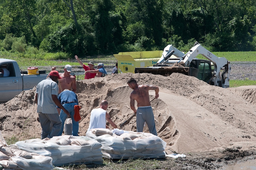 Volunteers fill sand bags, using machines to assist them as flood water from the swelling Missouri river threatens the communities surrounding Bean Lake Missouri, June 24, 2010. After weeks of heavy rains, Governor Jay Nixon declares a state of emergency on June 21, with the 139th Airlift Wing in St. Joseph Mo., taking command in North West Missouri for the National Guard.  (U.S. Air Force photo by Master Sgt. Shannon Bond/Released)