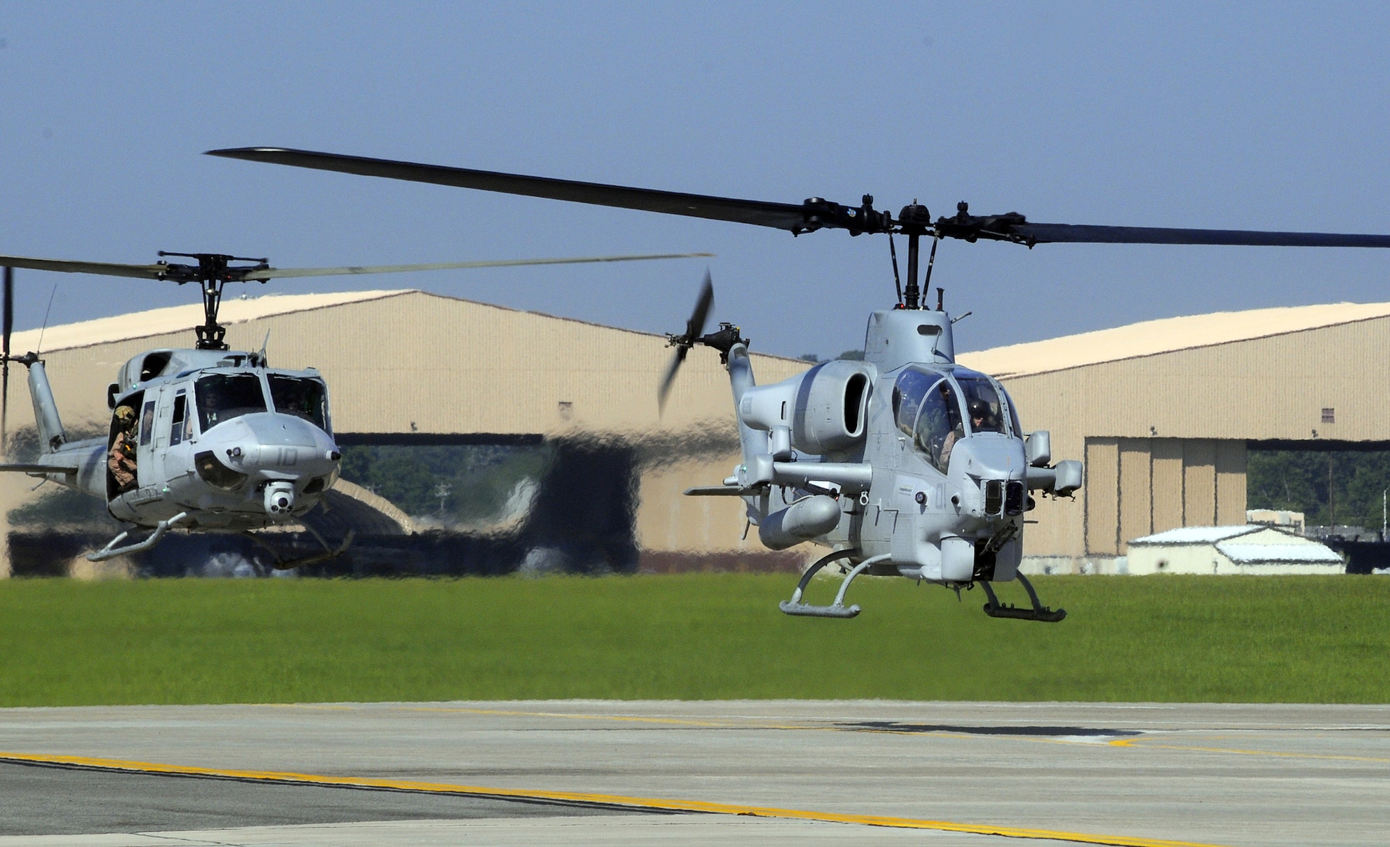 L-R, A UH-1N Huey and an AH-1W Cobra hover taxi onto Robins flightline Jine 18. U. S. Air Force photo by Sue Sapp