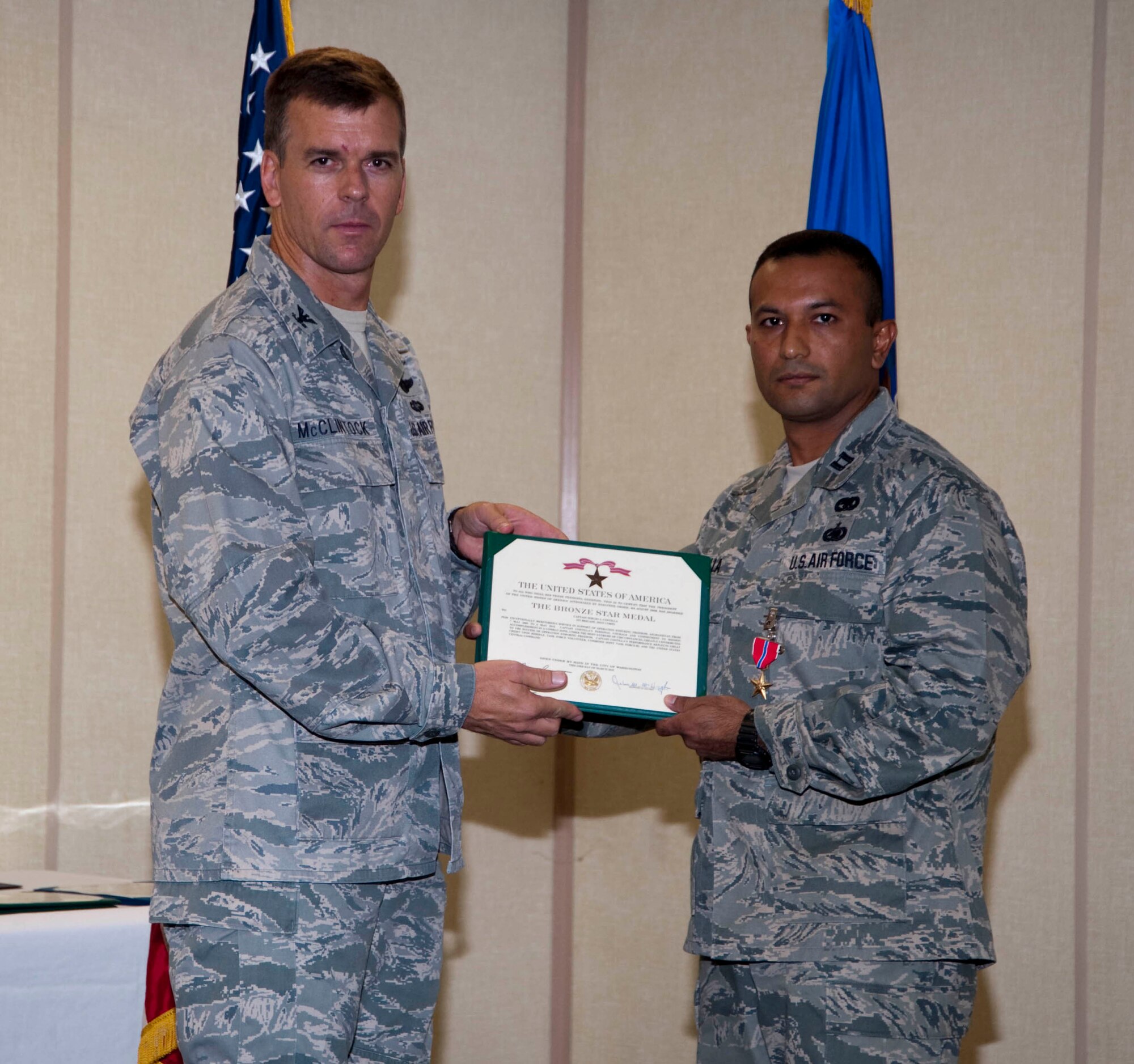 EGLIN AIR FORCE BASE, Fla. -- Col. Bruce McClintock, 96th Air Base Wing commander, presents a Bronze Star to Capt. Sergio Costilla, 96th Logistics Readiness Squadron, at a Commander's Call June 24.  Capt. Costilla displayed exceptional meritorious service while deployed to Afghanistan for a year in support of Operation ENDURING FREEDOM. He supported 82 combat outposts while traveling 3,600 miles in hostile terrain, often exposed to enemy fire. (USAF photo/Wendall Rowan)