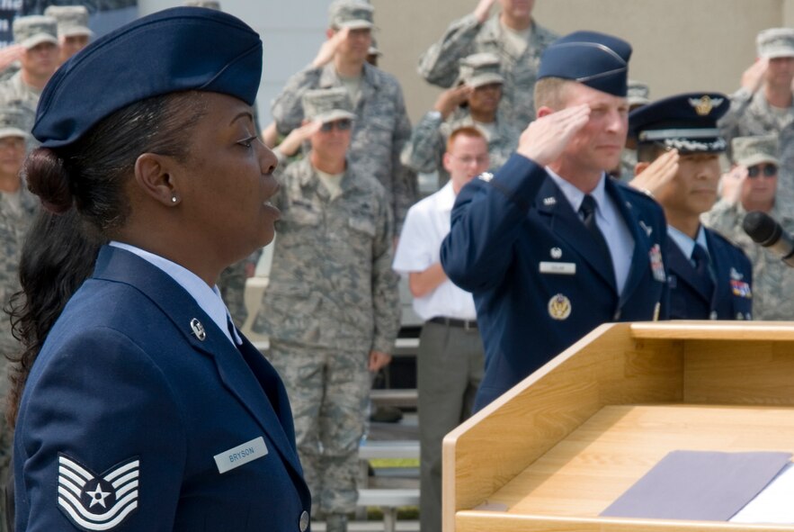 KUNSAN AIR BASE, Republic of Korea -- Tech. Sgt. Sonya Bryson sings the national anthem as Col. John Dolan, 8th Fighter Wing commander, and Col. Jae Hun Choi, 38th Fighter Group commander, render salutes during the 60th anniversary of the Korean War commemoration ceremony held at the base flag pole. In total, 51 Korean War veterans attended the ceremony, including Sang Don Sin, Korean War Veterans Association Gunsan Chapter Vice Chairman. (U.S. Air Force photo/Staff Sgt. Jonathan Pomeroy)