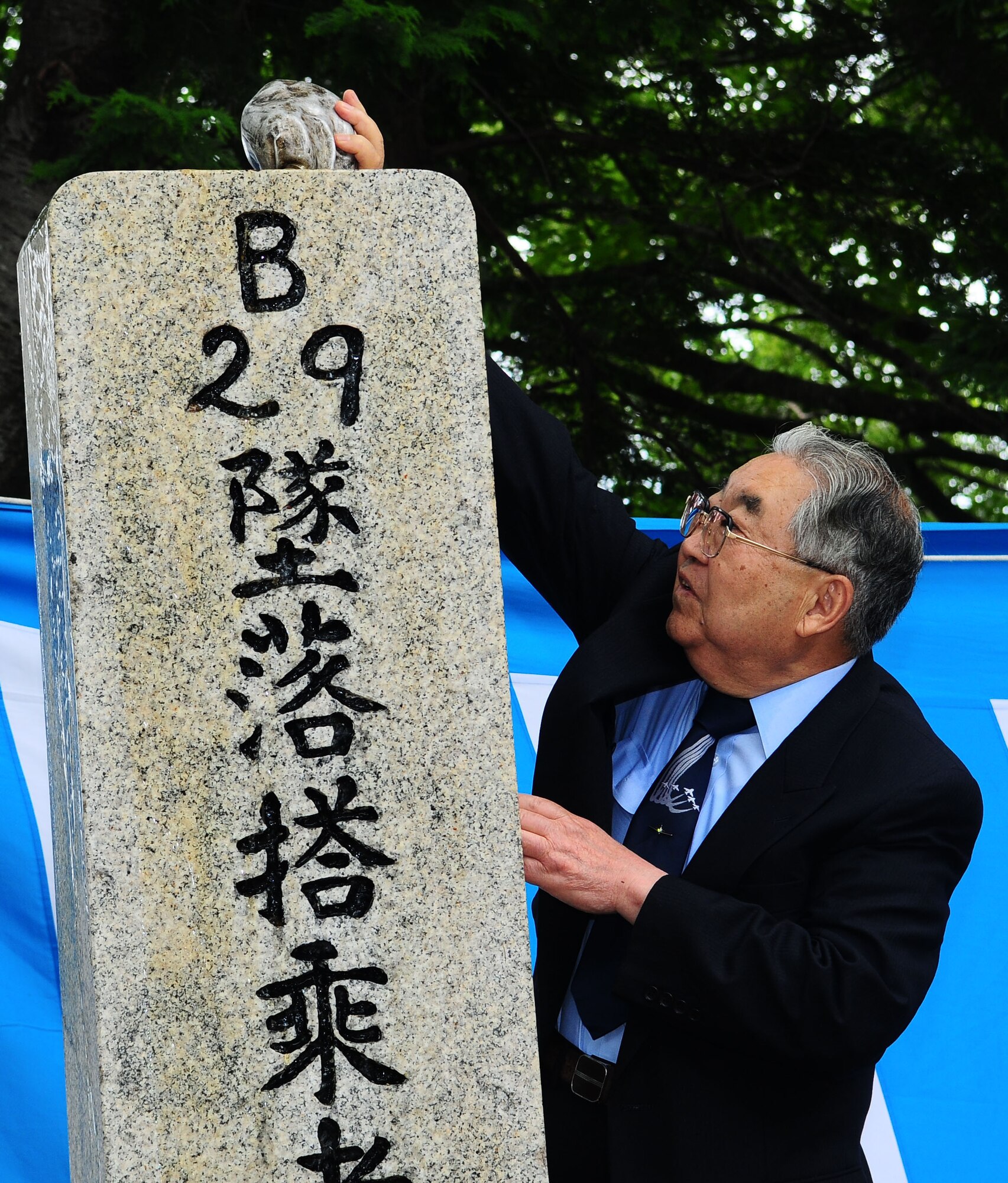 SHIZUOKA, Japan -- Dr. Hiroya Sugano, host of the B-29 Memorial Ceremony, pours Bourbon on a memorial June 12. The ceremony was held to remember the 23 fallen Airmen and Japanese civilians that died during the bombing raid that leveled 66 percent of Shizuoka city. (U.S. Air Force photo/Airman 1st Class Sean Martin)