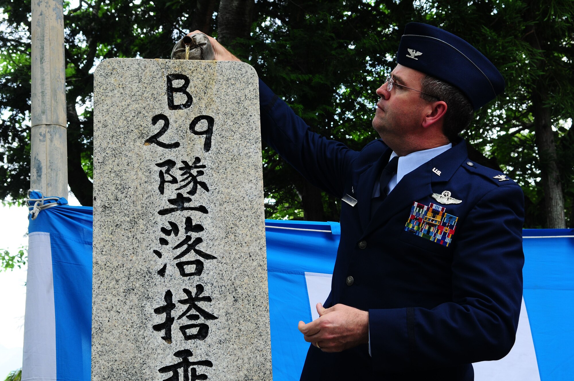 SHIZUOKA, Japan -- Col. Mark Hering, 374th Operations Group commander, pours Bourbon on a memorial June 12 during the B-29 Memorial Ceremony. The ceremony was held to remember the 23 fallen airmen and Japanese civilians that died during the bombing raid that leveled 66 percent of Shizuoka city. (U.S. Air Force photo/Airman 1st Class Sean Martin)