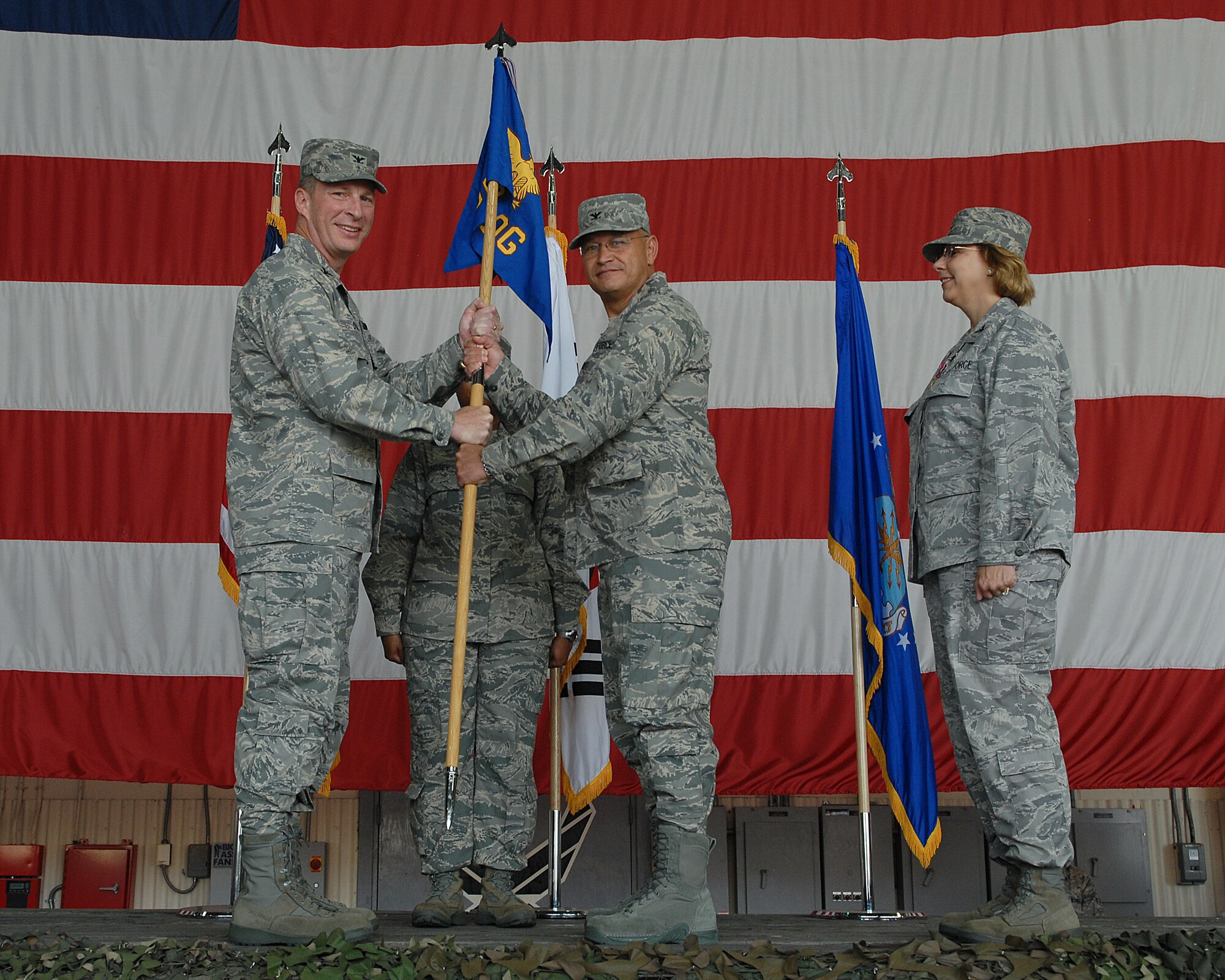 KUNSAN AIR BASE, Republic of Korea -- Col. John Dolan, 8th Fighter Wing commander, presents the guidion to Col. Steven Caberto during the 8th Medical Group Change of Command Ceremony June 25. Colonel Caberto is replacing the former commander Col. Janet Deltuva.    (U.S. Air Force photo/ Senior Airman Roy Lynch)