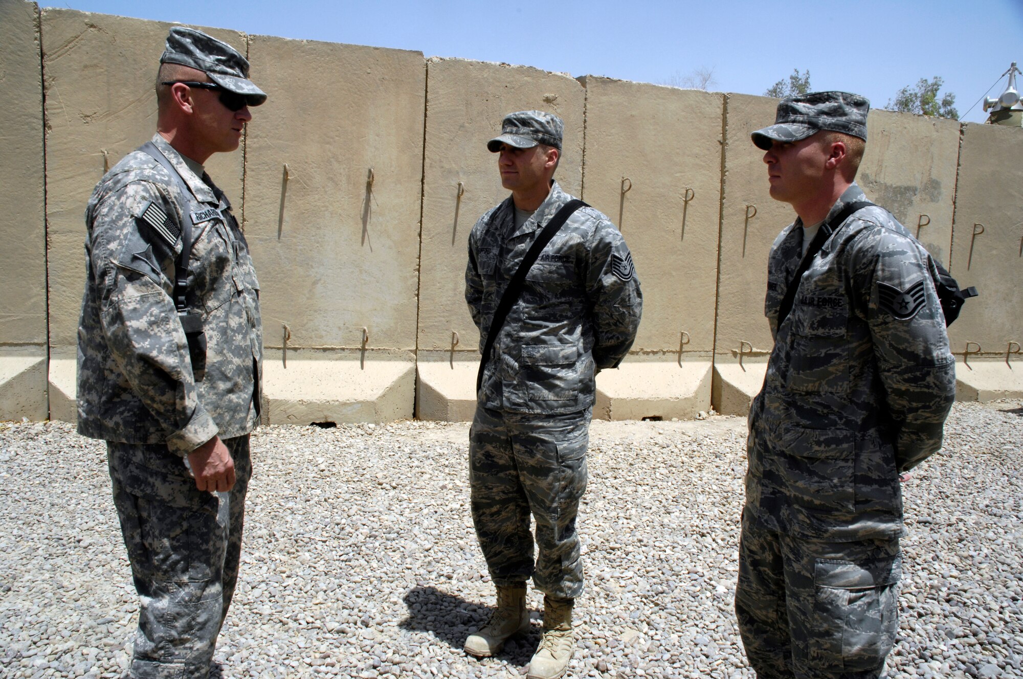 Sgt. Maj. Jerry Richardson (left), U.S. Air Force-Iraq, presented coins on behalf of Army Brig. Gen. Gustave Perna, USF-I J4 director, and himself to Tech. Sgt. Aaron Gufford (center) and Staff Sgt. Jeffery Kirker (right), both of the 392nd Expeditionary Signal Battalion at Camp Liberty, Iraq, to say thanks for their quick reactions in saving Lt. Col. Mitchell Malone's life outside the Liberty Gym June 7. The presentation of a coin to someone who has done an outstanding job is a time-honored military tradition observed by all branches of the military. (U.S. Air Force photo by Staff Sgt. Sanjay Allen/Released)