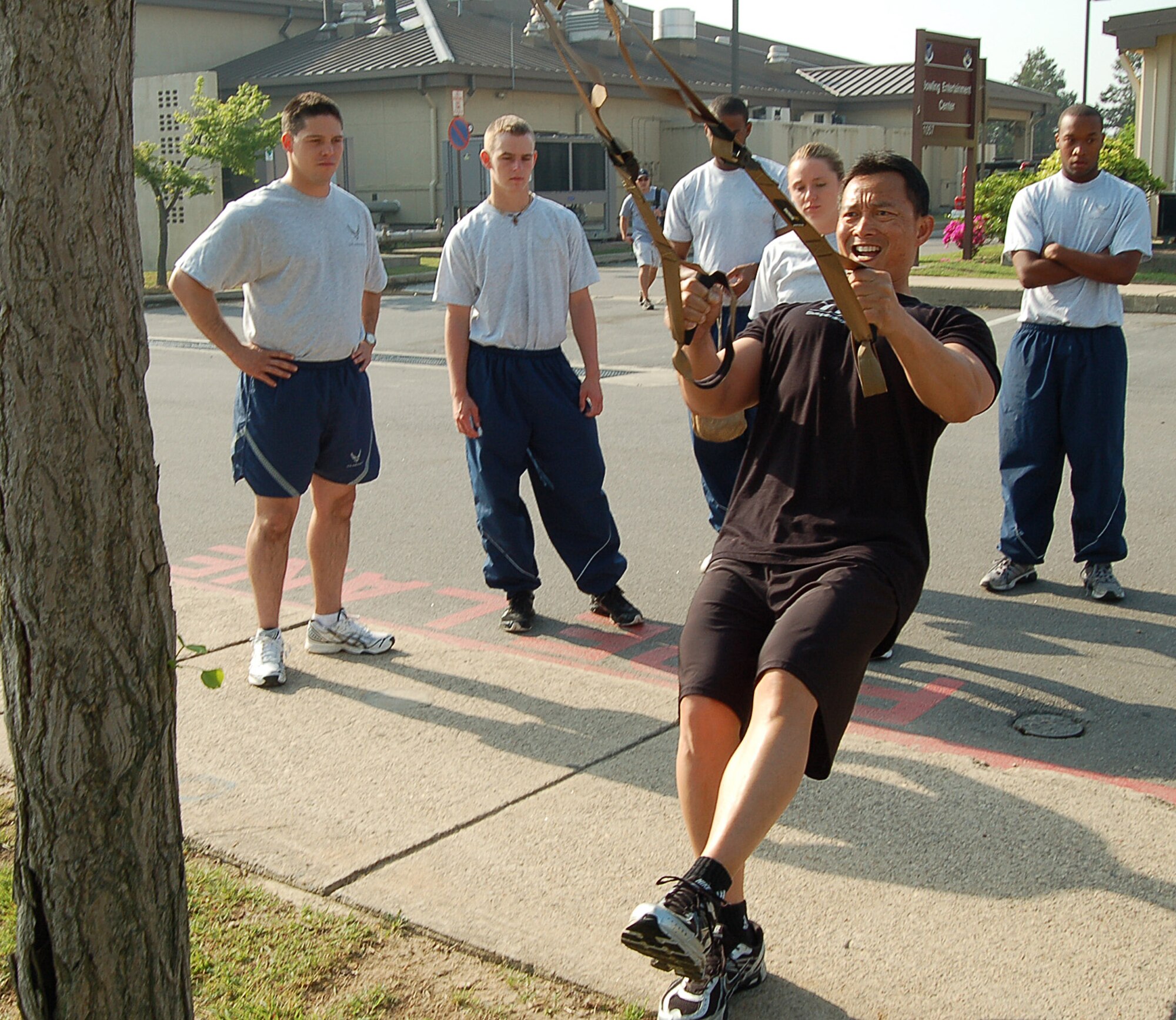 KUNSAN AIR BASE, Republic of Korea -- Benny Miguel, 8th Force Support Squadron fitness center director, shows Airmen how to use the Total Resistance Exercise system. TRX is a mobile fitness system that uses a suspense harness and your own body weight to workout.  (U.S. Air Force photo/Senior Airman Roy Lynch)
