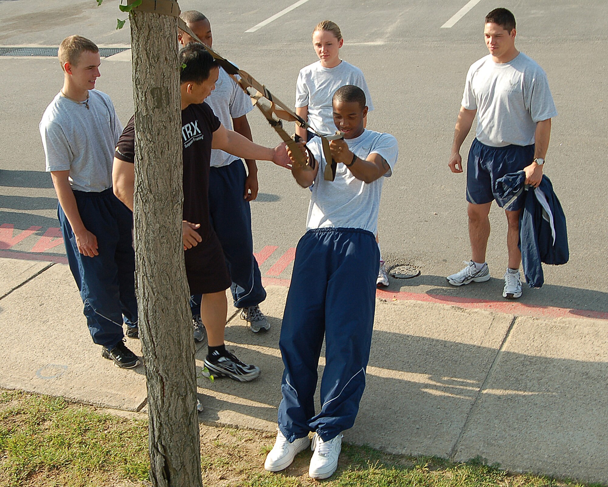 KUNSAN AIR BASE, Republic of Korea -- Benny Miguel, 8th Force Support Squadron fitness center director, directs Airmen in the use of the Total Resistance Exercise system. TRX is a mobile fitness system that uses a suspense harness and your own body weight to workout.  (U.S. Air Force photo/Senior Airman Roy Lynch)